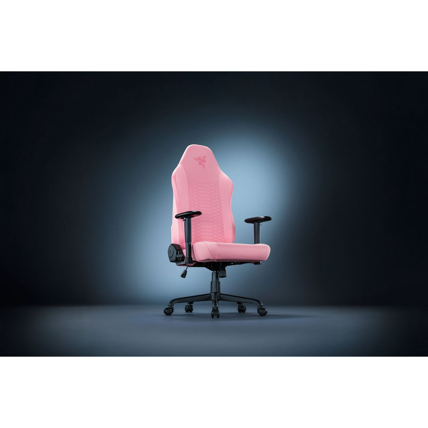 Une chaise gaming Razer rose avec accoudoirs et base noirs. Le fond est un dégradé sombre, avec un projecteur sur la chaise.