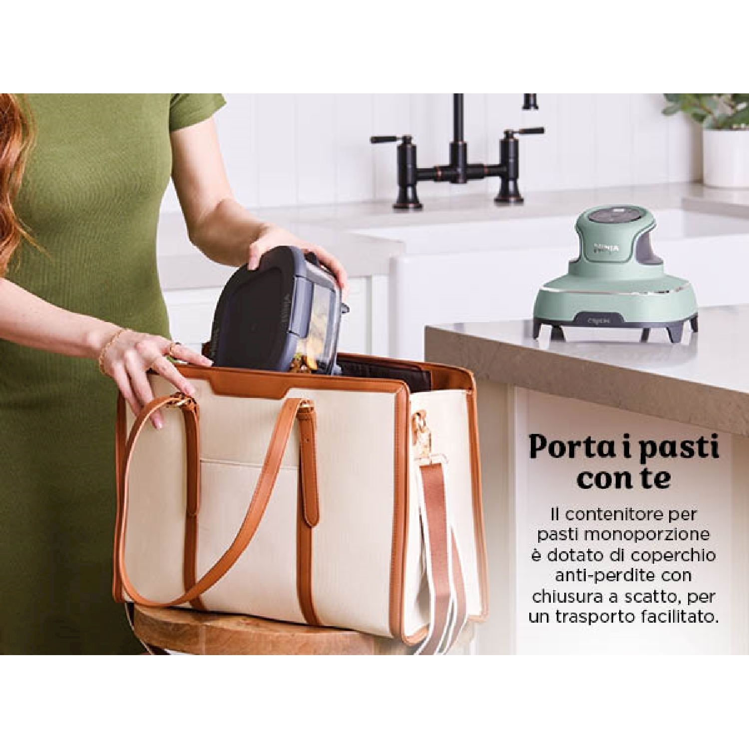 Una donna in verde mette un contenitore nero in una borsa tote color crema. Un elettrodomestico verde è sul bancone.
