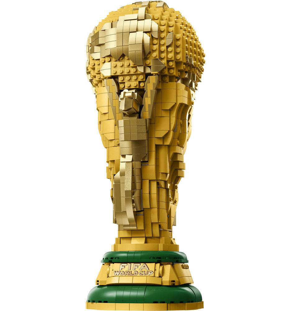 Eine Lego FIFA-Weltmeisterschaftstrophäe. Sie ist golden, auf einer grünen und goldenen Basis gebaut. Die Trophäe steht vor weißem Hintergrund.