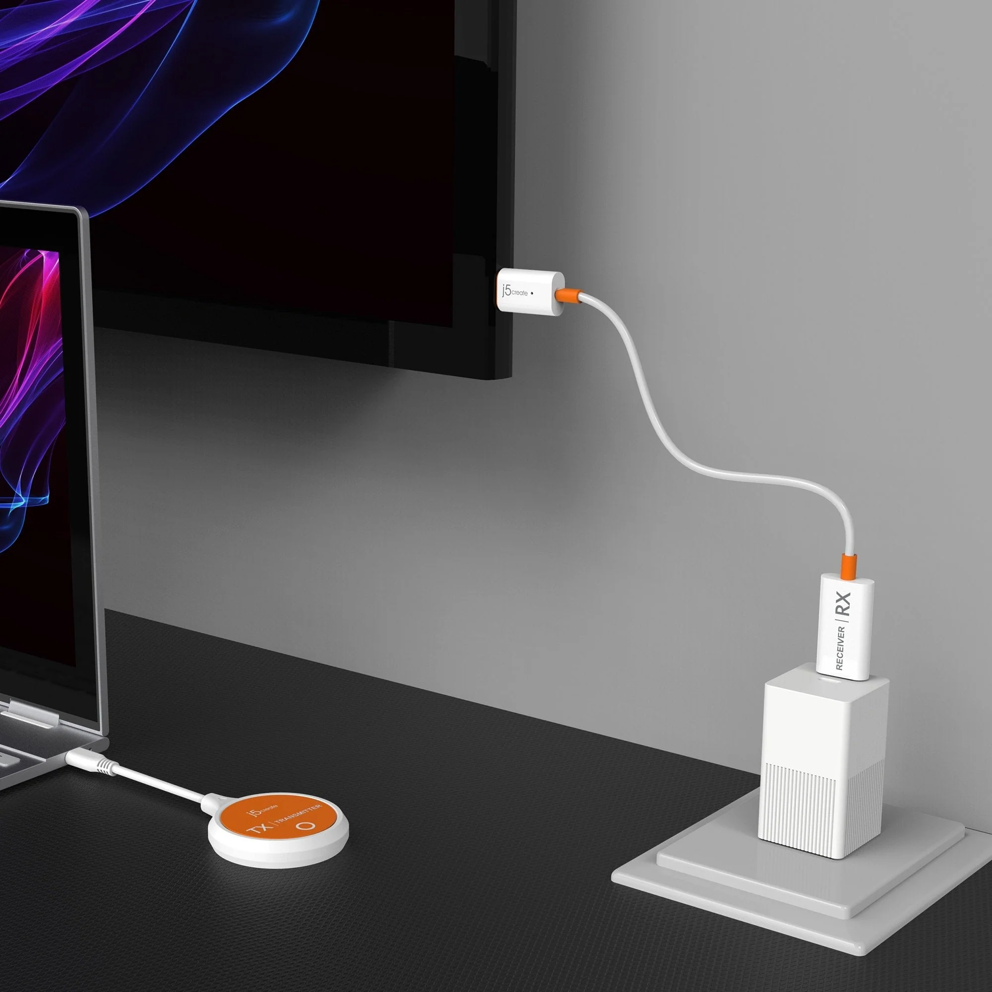 Laptop, TV és eszközök csatlakoztatva. Fehér kábelek kötik össze az eszközöket. Fekete asztal és szürke fal.