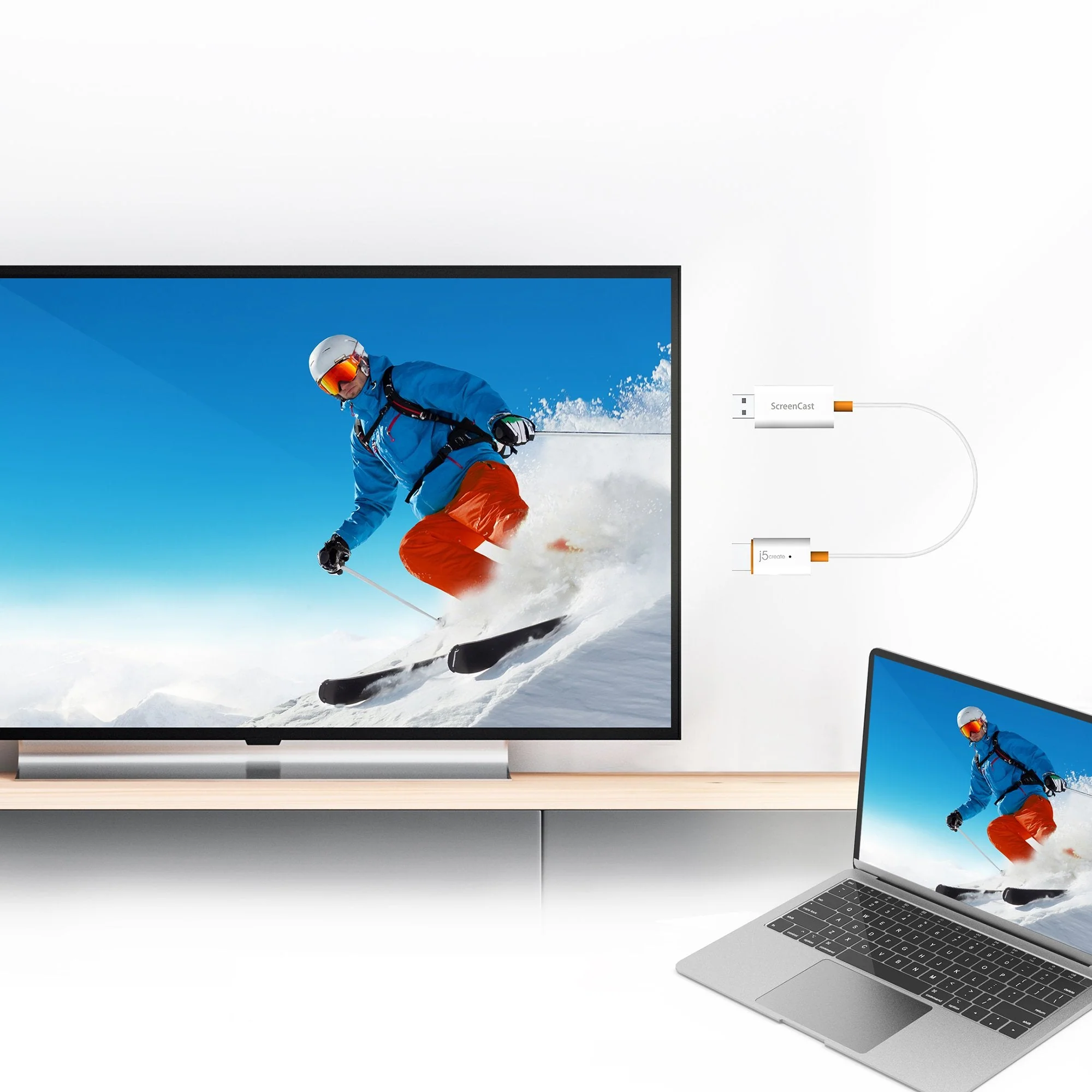 A TV síelőt jelenít meg. A laptop ugyanazt a képet mutatja. Egy kábel köti össze a két eszközt.