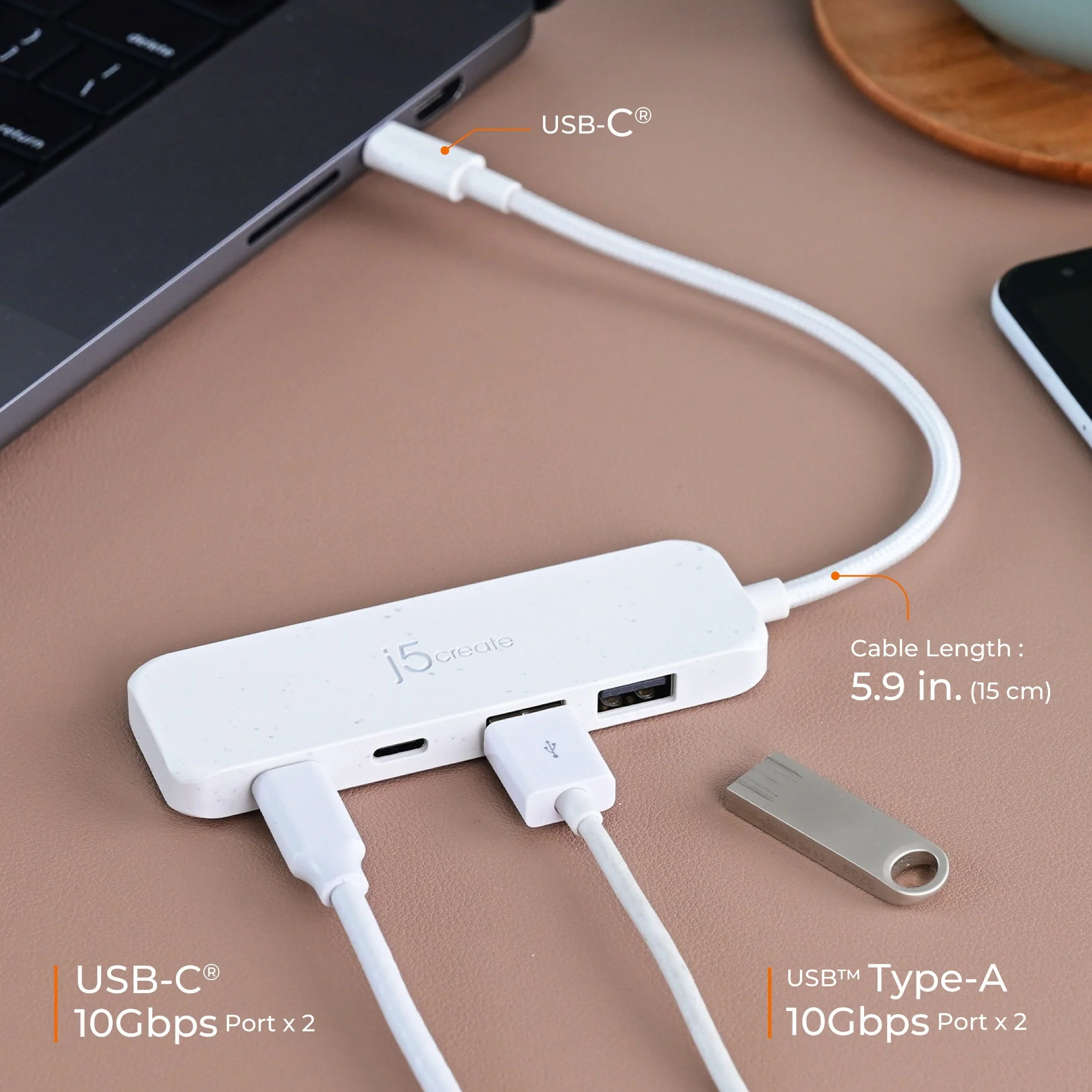 Egy fehér USB hub több porttal egy laptophoz csatlakozik. Egy USB meghajtó van mellette. A háttér egy íróasztal.