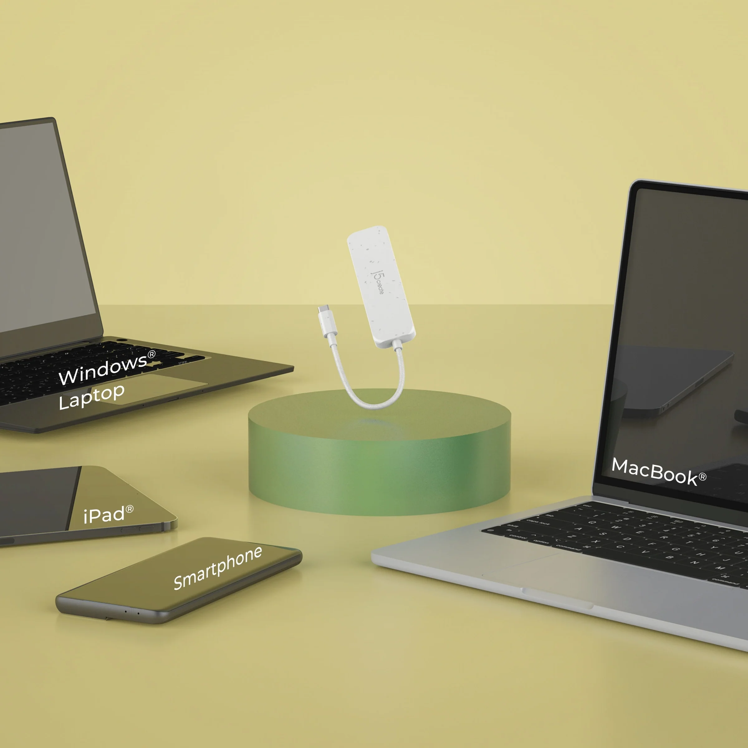 Egy fehér USB-C hub egy zöld platformon, laptop, iPad, okostelefon és MacBook veszi körül.