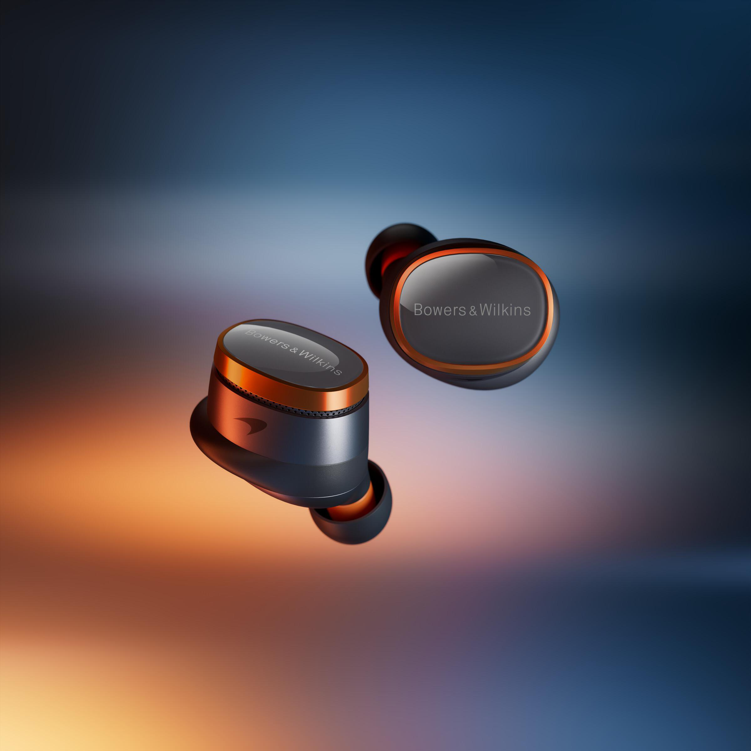 Zwei kabellose schwarze und orangefarbene Ohrhörer mit der Marke Bowers & Wilkins auf einem Farbverlaufshintergrund.