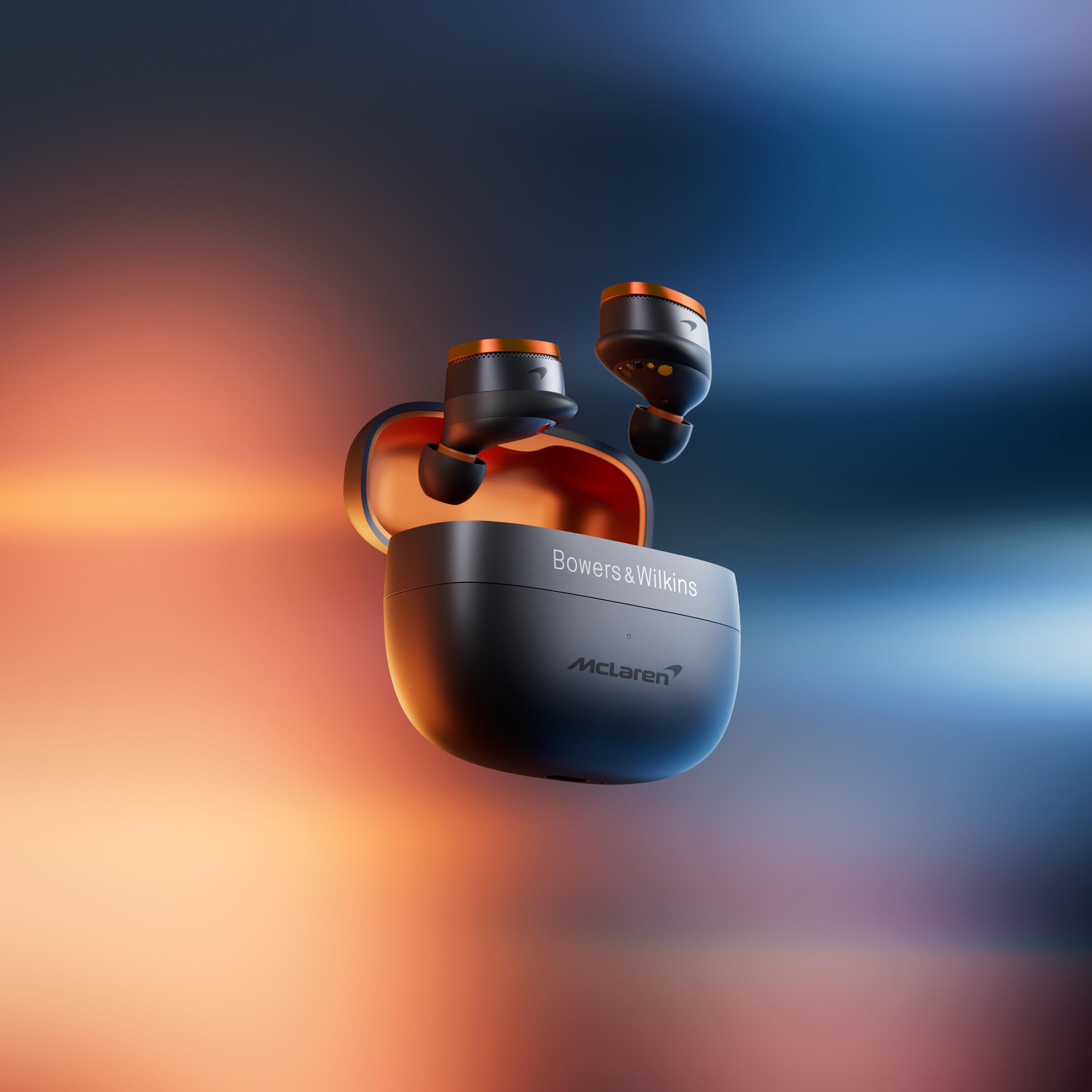 Schwarze und orangefarbene kabellose Ohrhörer und Etui, McLaren- und Bowers & Wilkins-Branding, auf Gradientenhintergrund.