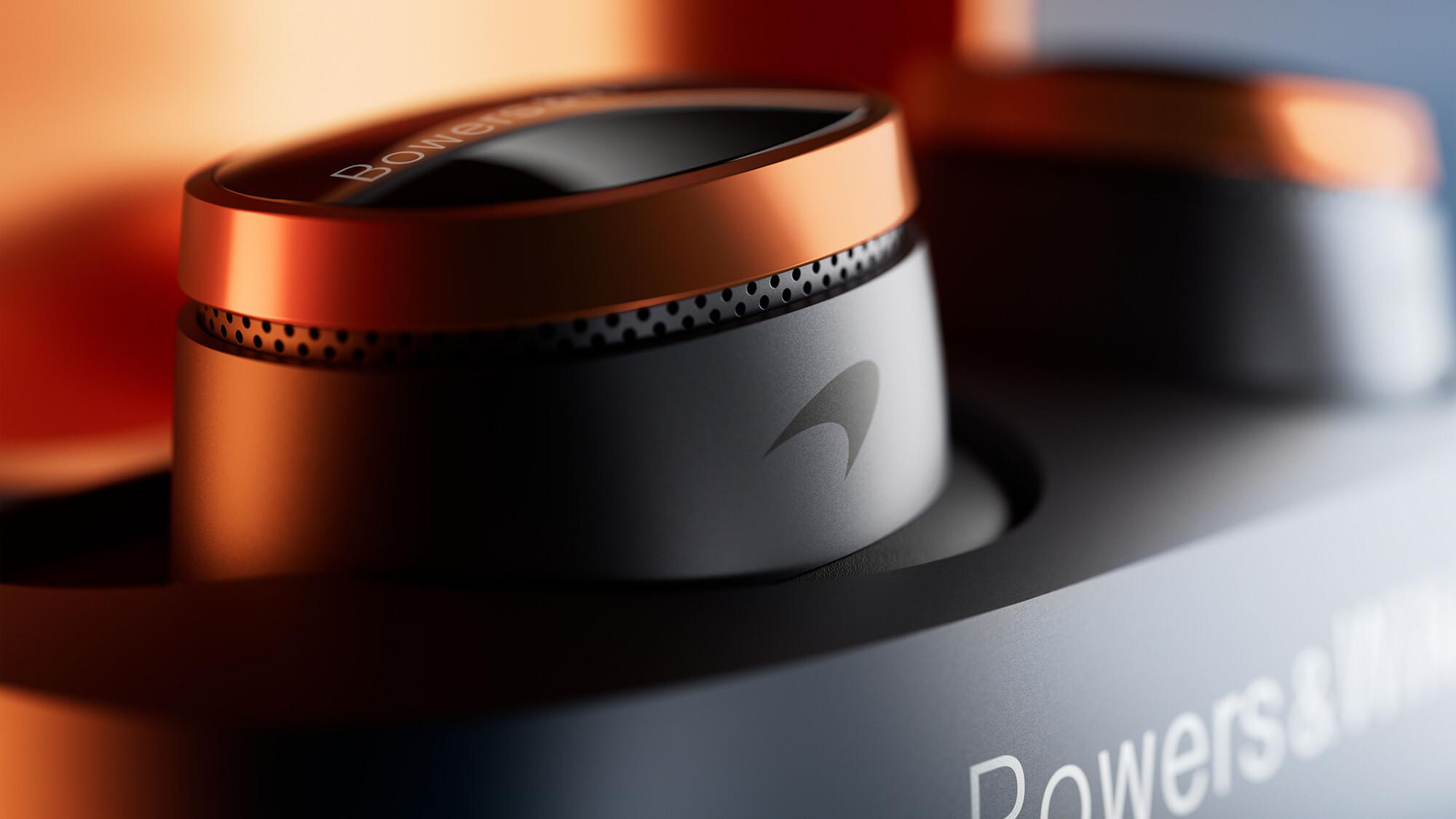 Nahaufnahme eines schwarzen und kupferfarbenen Bedienknopfs mit McLaren-Logo, Teil eines Bowers & Wilkins-Geräts.
