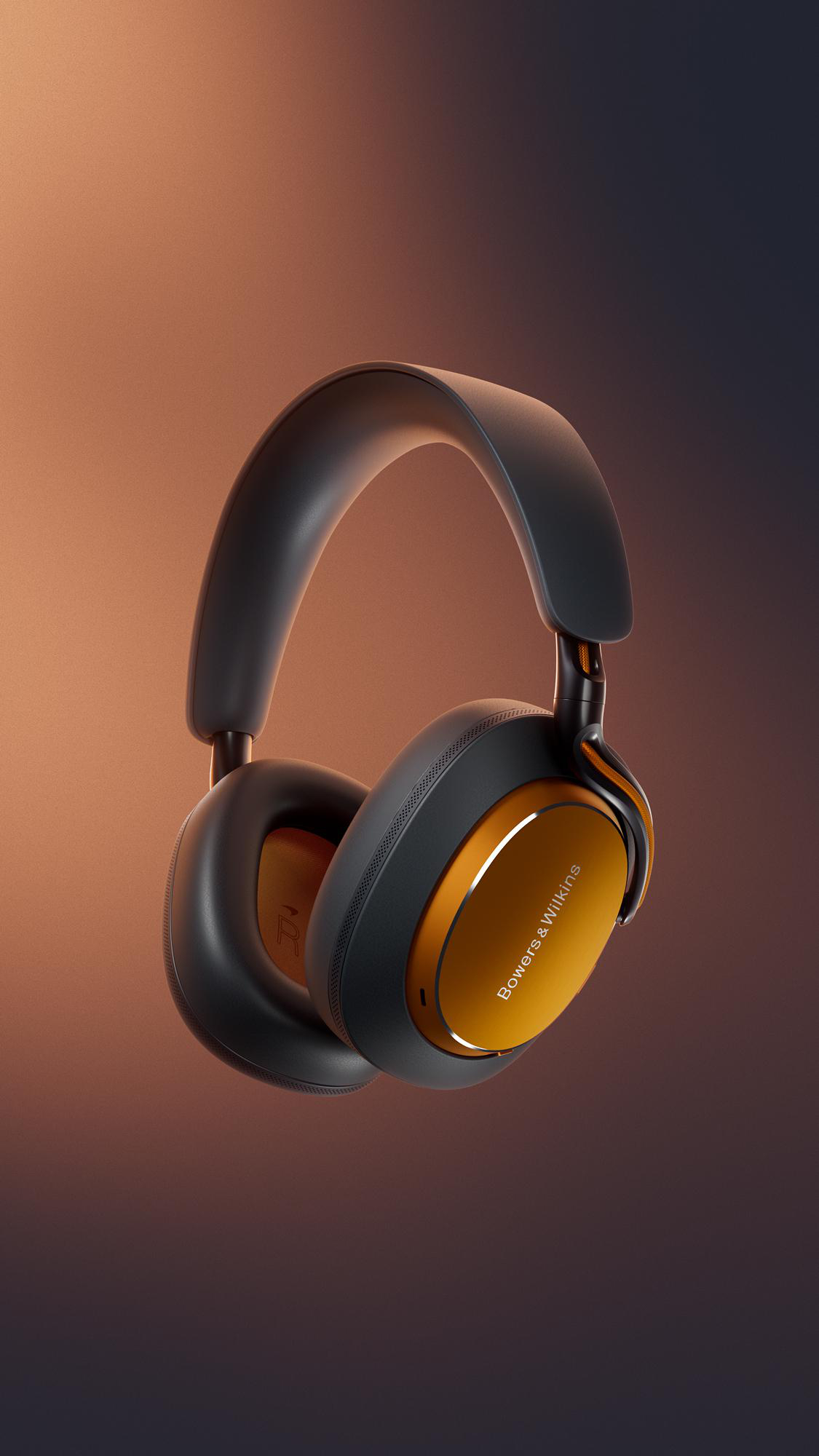 Over-Ear-Kopfhörer mit schwarz-goldenem Design. Bowers & Wilkins Logo auf der Ohrmuschel. Brauner Farbverlauf im Hintergrund.