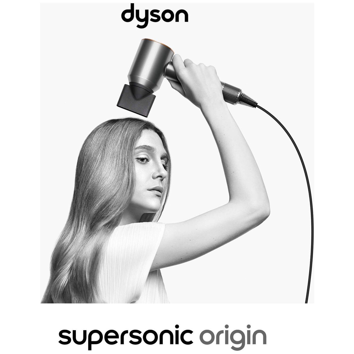 A woman holds a Dyson hair dryer. The hair dryer is pointed at her hair. The Dyson and 'supersonic origin' are displayed.
