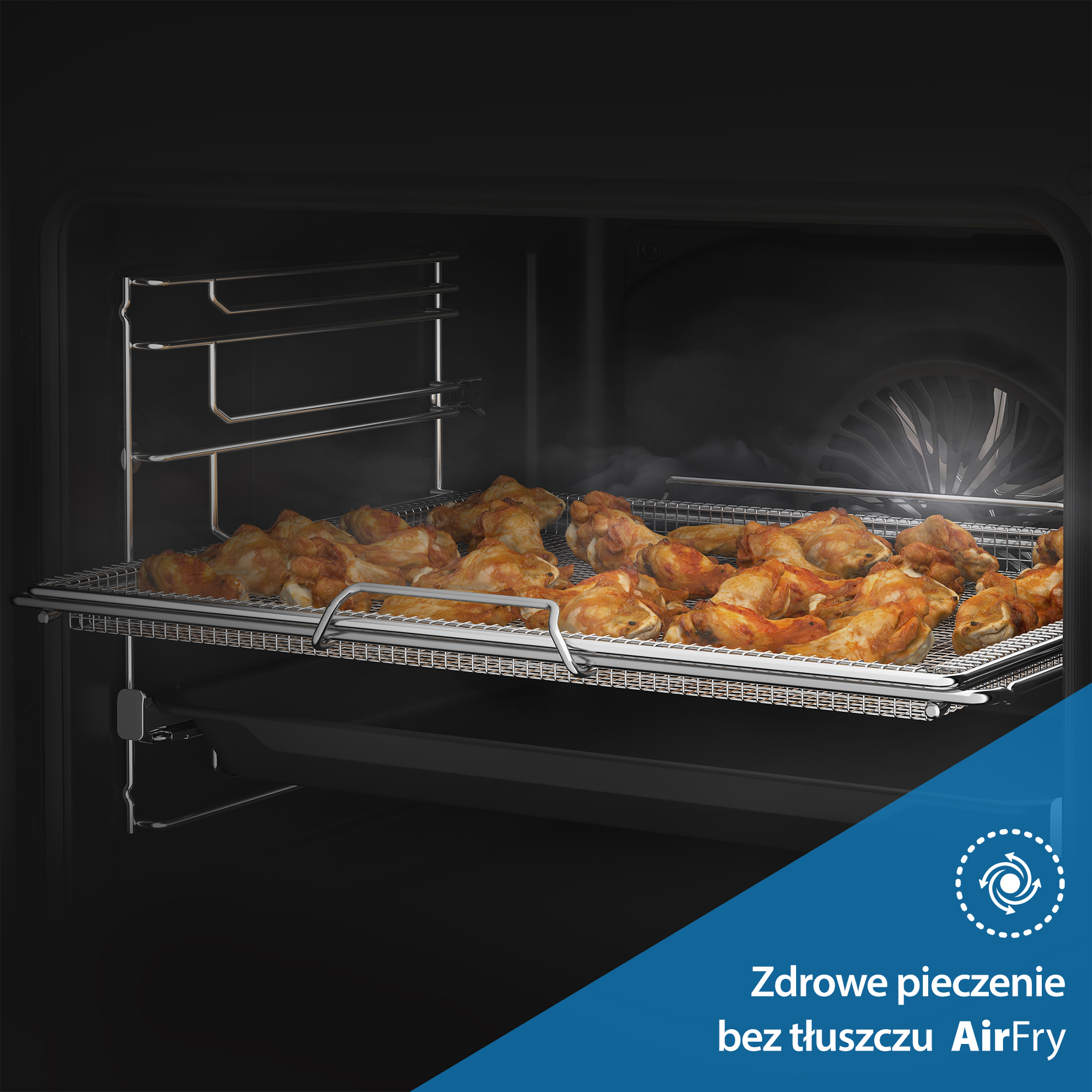W piekarniku upieczone skrzydełka z kurczaka na drucianym ruszcie. Widoczna para. Tekst na dole mówi: 'Zdrowe pieczenie bez tłuszczu AirFry'.