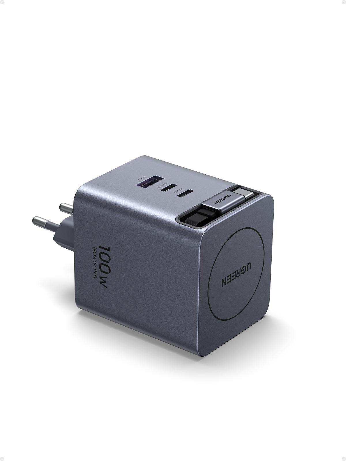 Un cargador gris UGREEN 100W Nexode Pro. Tiene múltiples puertos USB y un enchufe. El logotipo de UGREEN es visible.