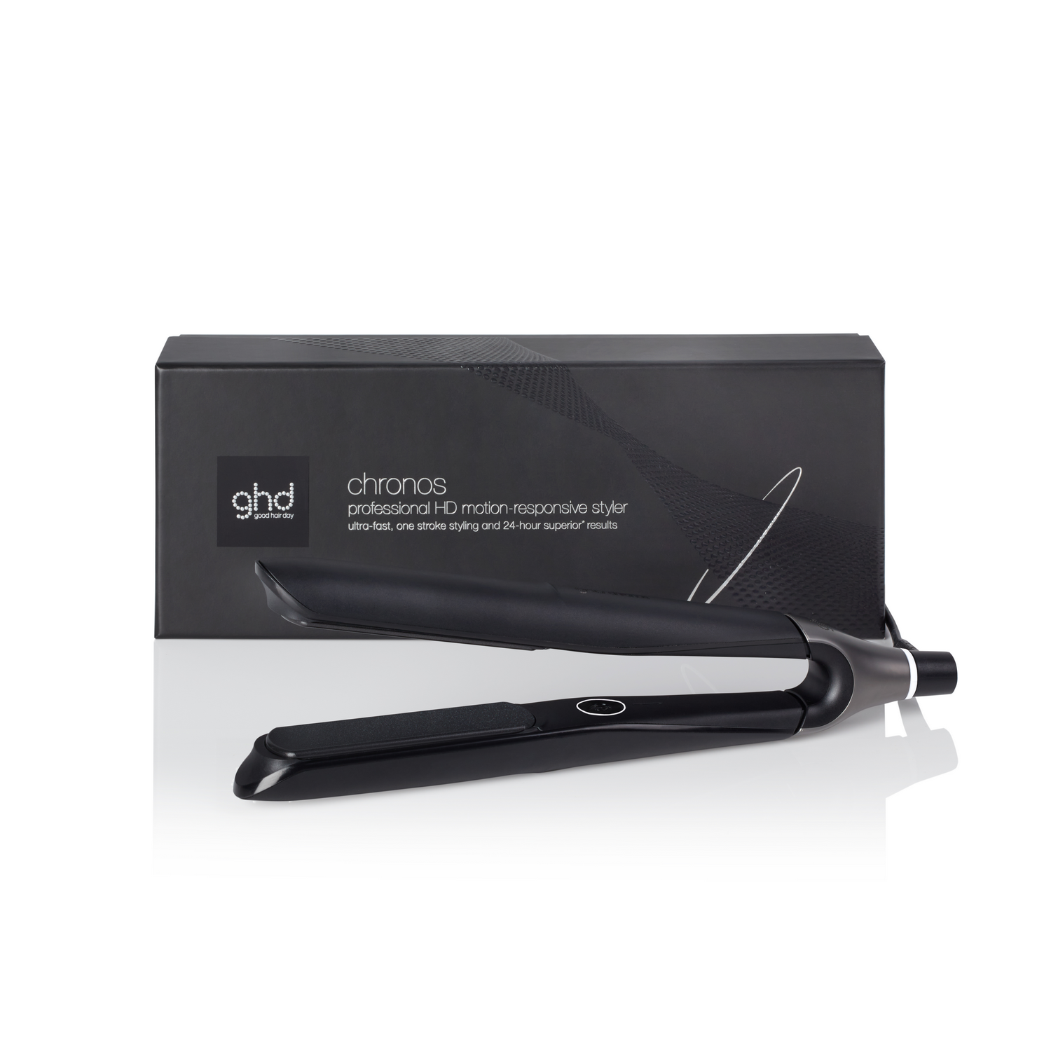 Una plancha de pelo negra con una caja negra detrás. La caja tiene el logotipo de ghd y la descripción del producto. Fondo blanco.