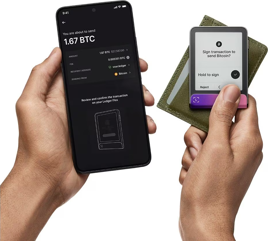 Mani che tengono un telefono e un Ledger. Il telefono mostra i dettagli della transazione Bitcoin. Ledger visualizza il prompt di firma.