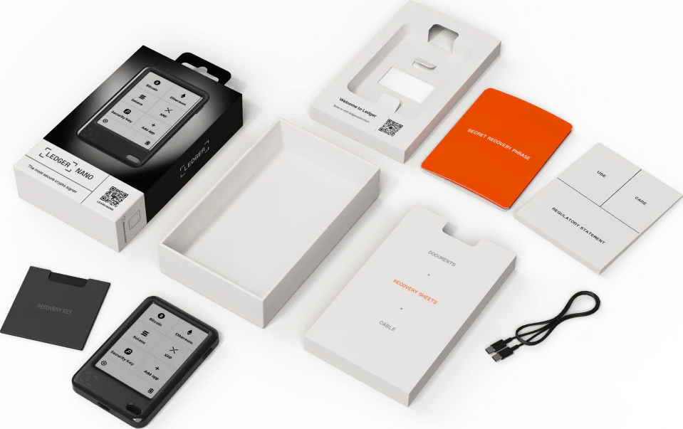 Ledger Nano Krypto-Signer-Kit mit Box, Gerät, Dokumenten und Kabel. Inhalt: Gerät, Wiederherstellungsschlüssel und Willkommensmaterialien.