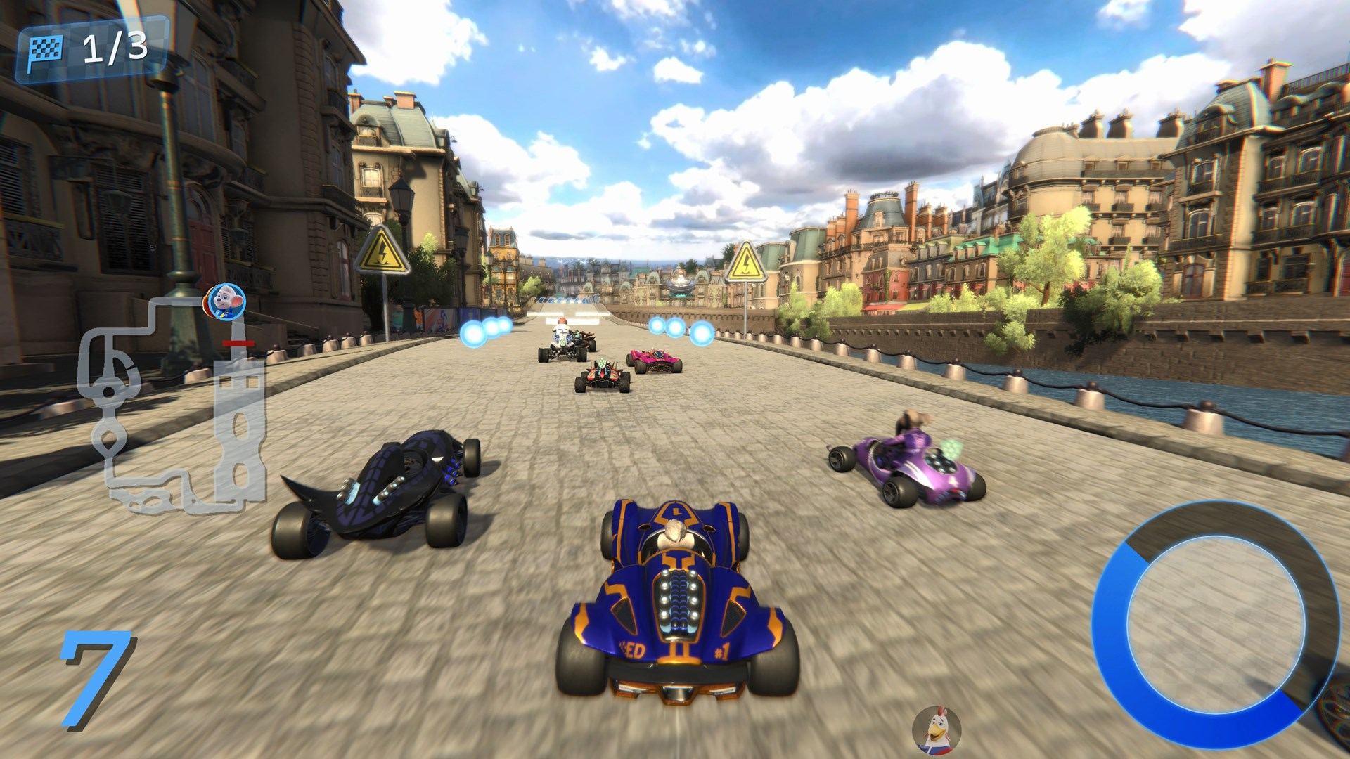 Kart-Rennspiel. Karts fahren auf einer Stadtstraße. Gebäude säumen die Straße, im Hintergrund ein Fluss, blauer Himmel mit Wolken.