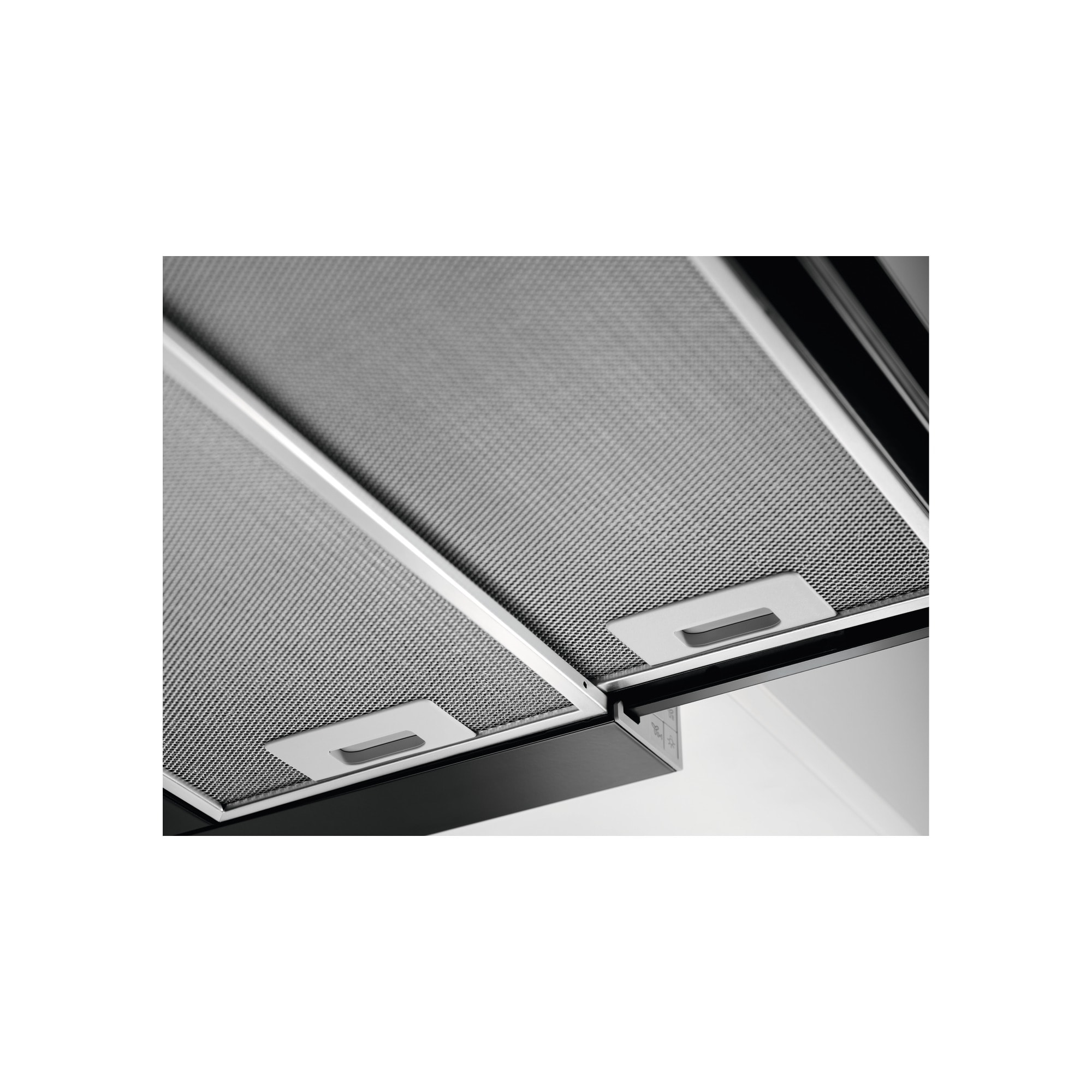 Zbliżenie okapu kuchennego z metalowym filtrem siatkowym i dwoma białymi uchwytami. Czarna ramka i białe tło.