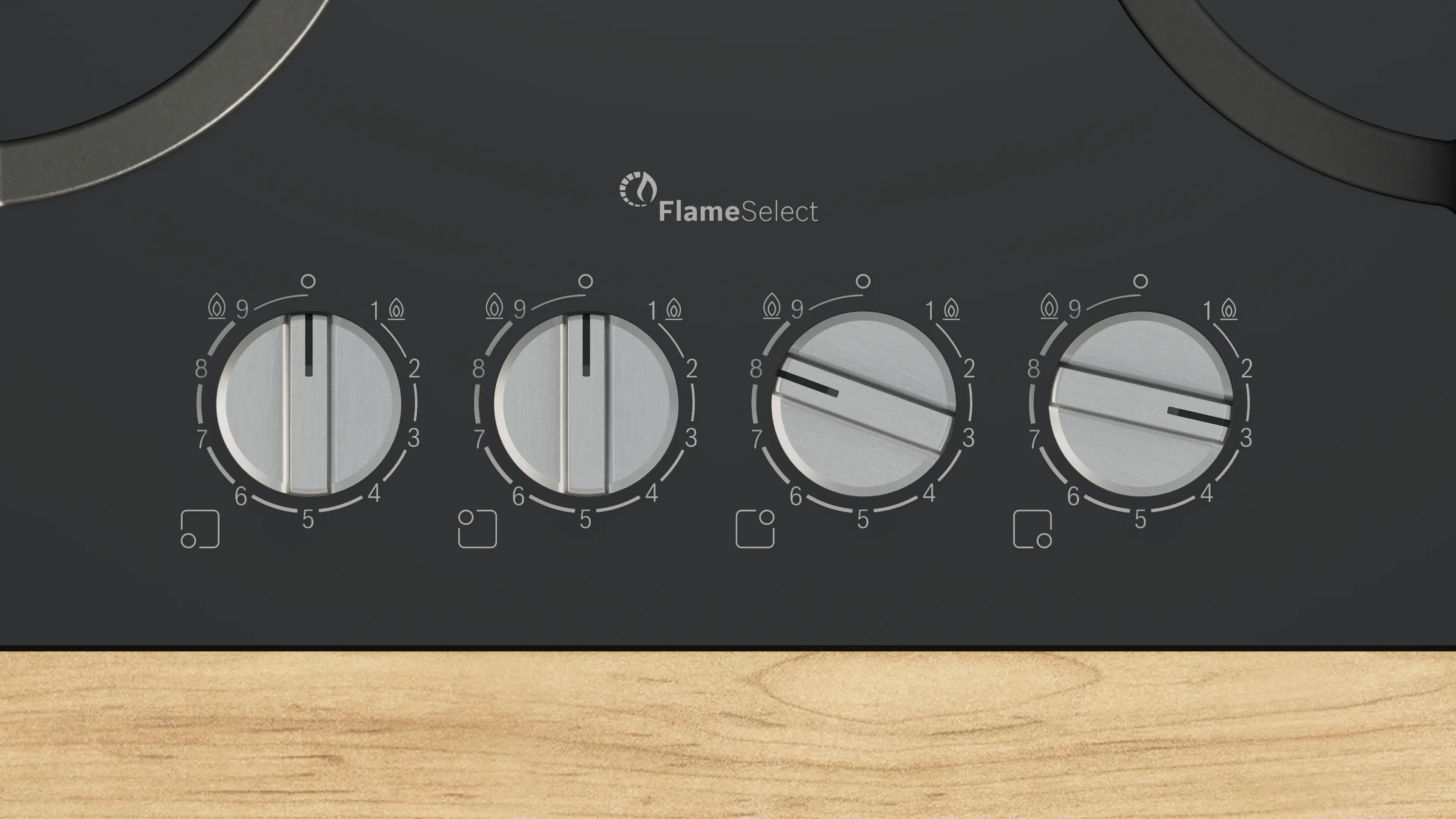 Primer plano de una estufa negra con cuatro diales plateados. Cada dial tiene números y un icono de llama. El fondo es de madera.
