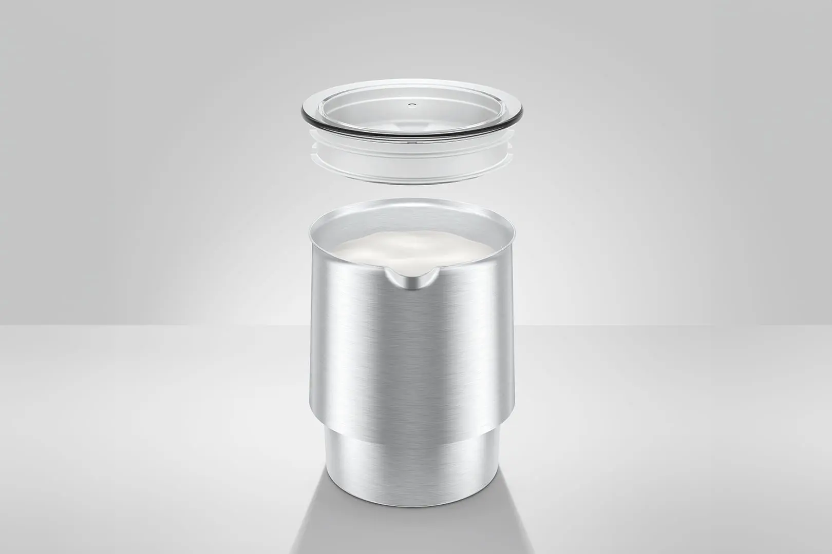 Un montalatte metallico con coperchio trasparente. Il montalatte è aperto, con liquido bianco all'interno.