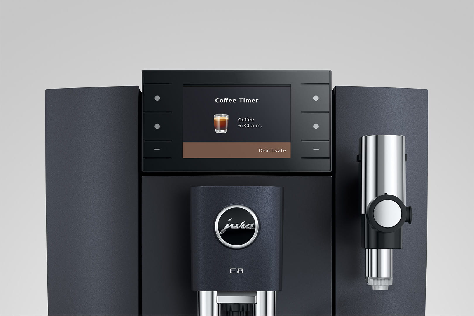 Primo piano di una macchina da caffè nera Jura E8. Lo schermo mostra il timer del caffè. A destra c'è un beccuccio argentato.