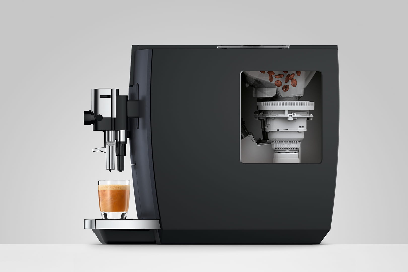 Macchina da caffè nera con bicchiere di caffè. All'interno, una sezione rivela chicchi e meccanismi. Accenti argentati.