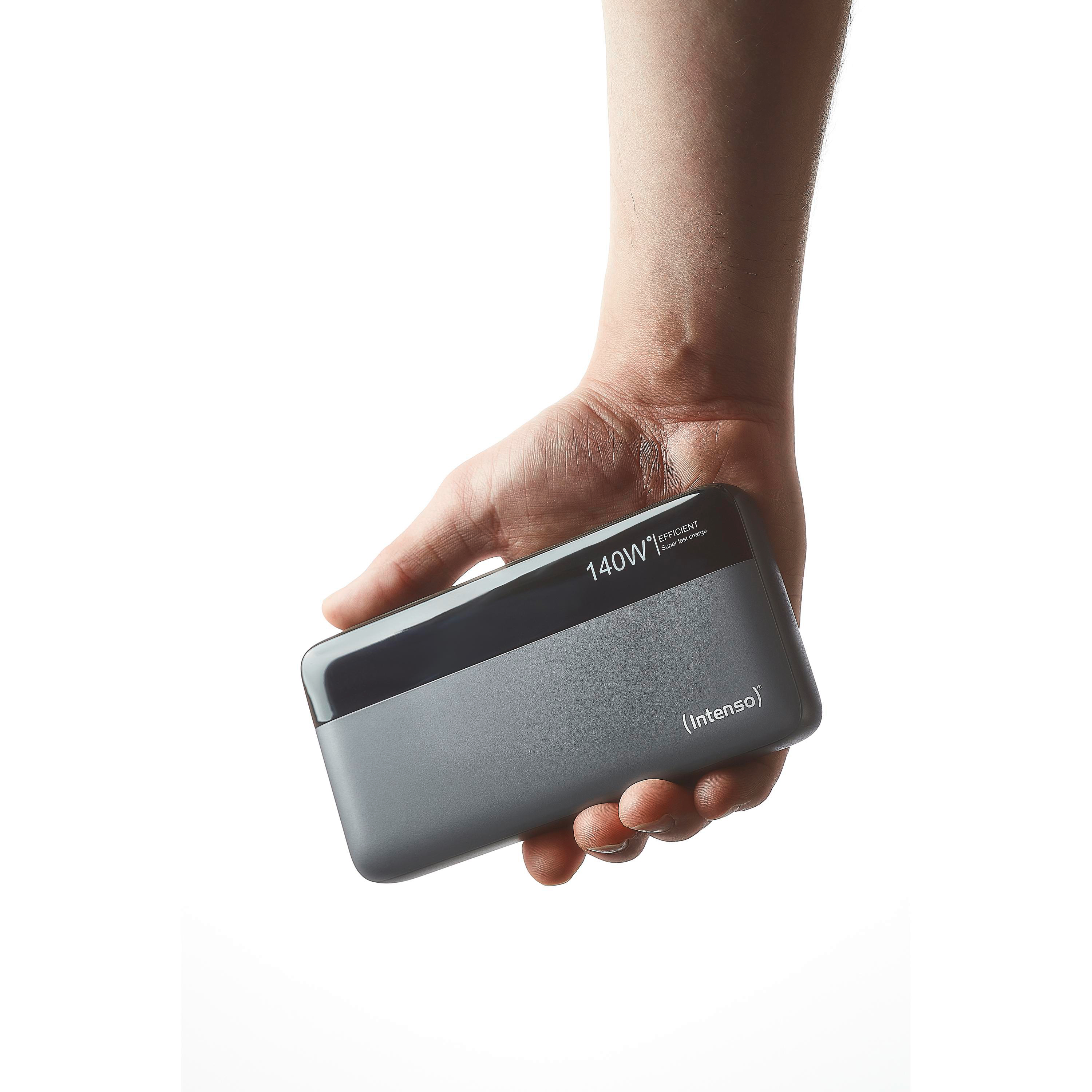 Eine Hand hält eine graue Powerbank mit der Aufschrift '140W' und '(Intenso)' vor weißem Hintergrund.