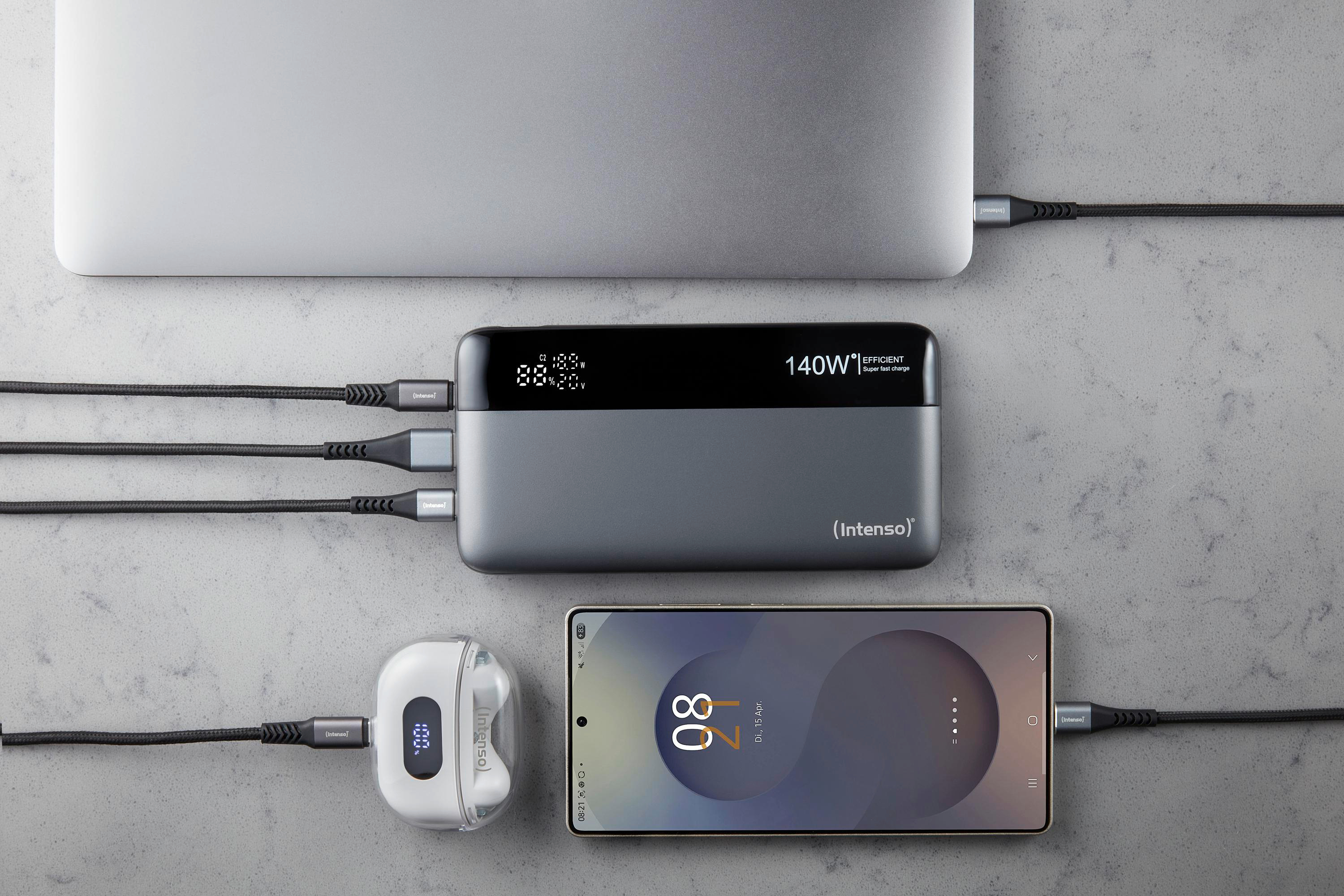 Laptop, Powerbank, Handy und Ohrhörer laden auf grauer Oberfläche mit Kabeln. Das Handy zeigt 80% Ladung an.