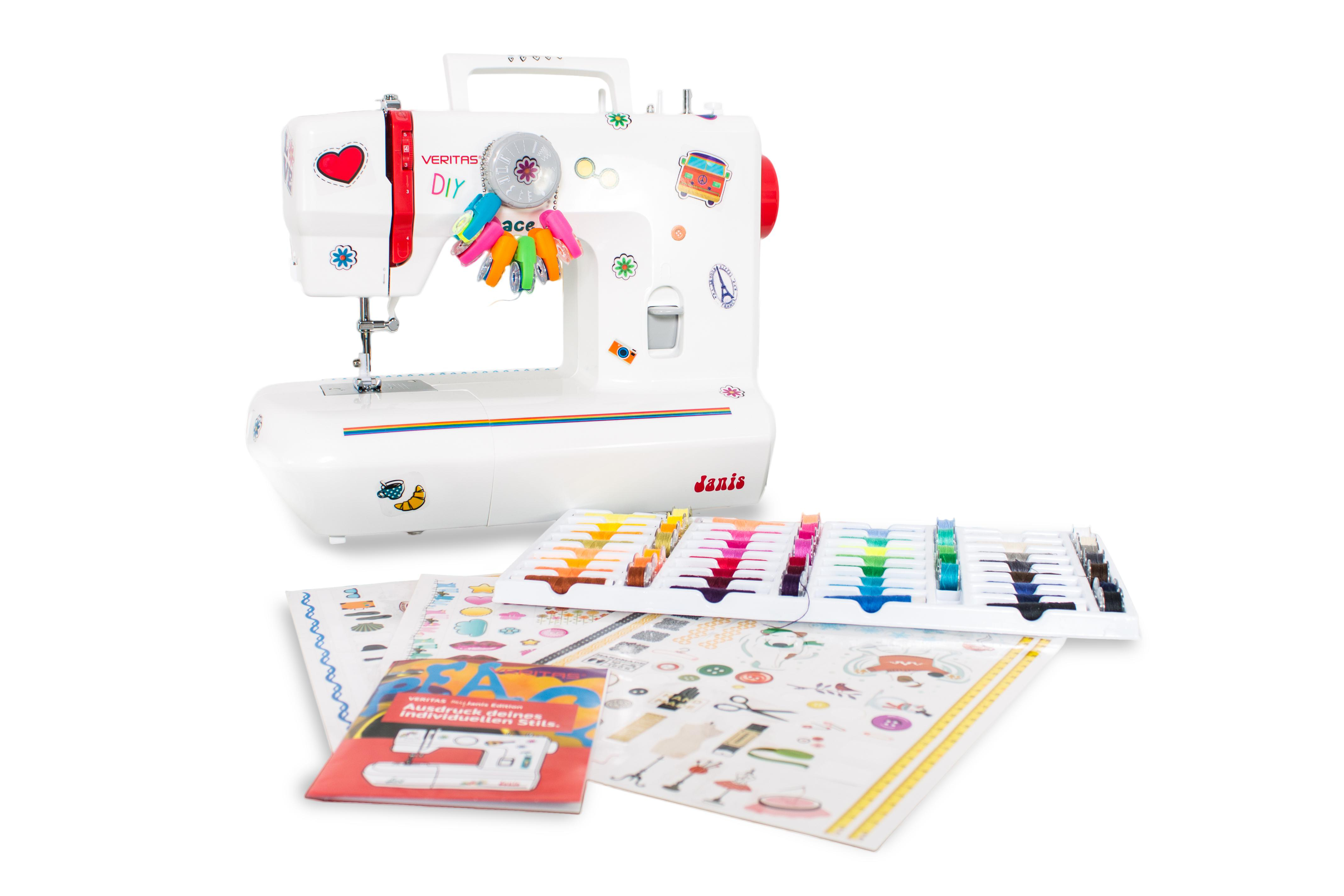 Eine weiße Nähmaschine mit bunten Aufklebern, Zubehör und einem Tablett mit Garnspulen auf weißem Hintergrund.