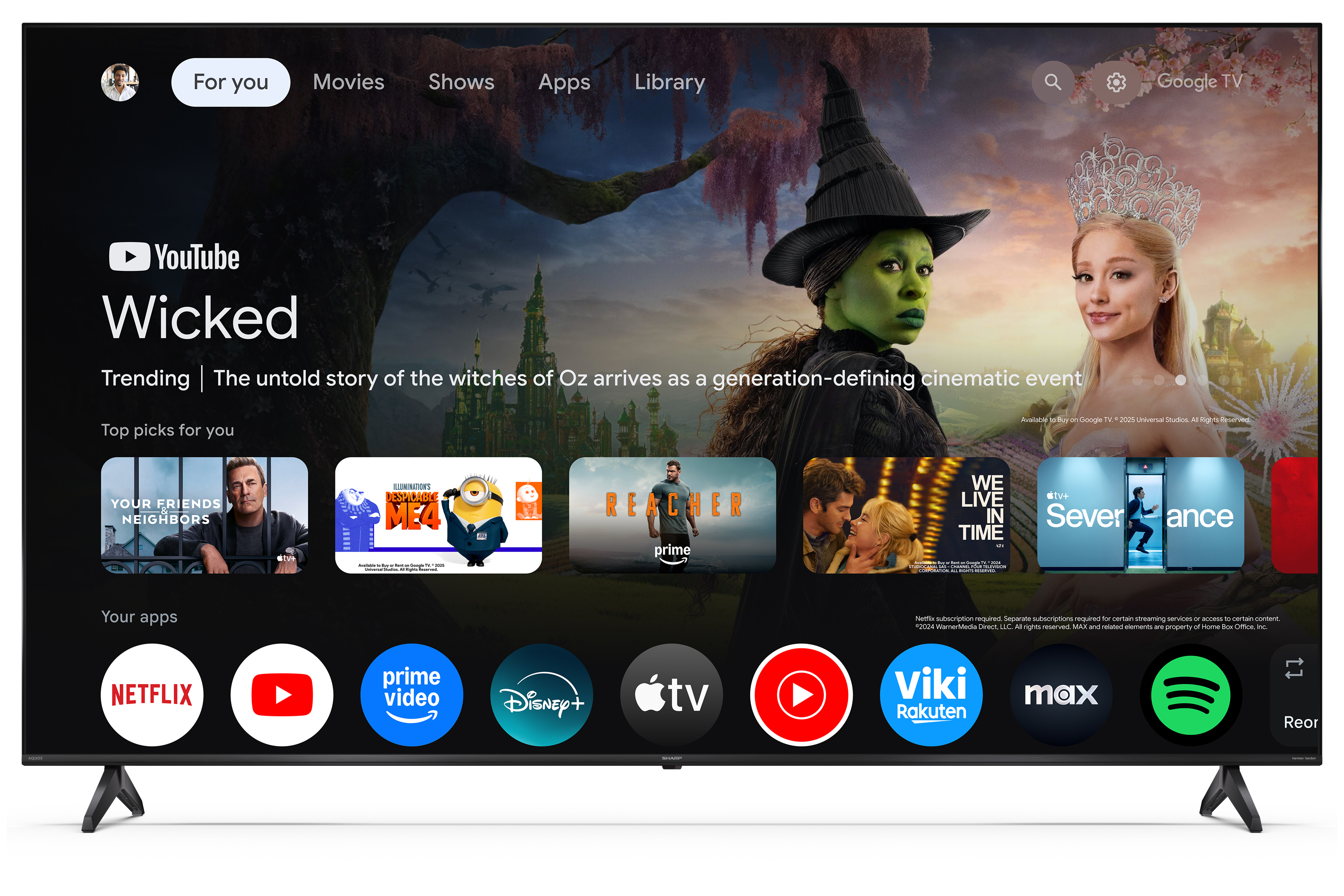 A TV képernyőjén a YouTube alkalmazás látható, a Wicked film promóciója boszorkány- és hercegnőképekkel.