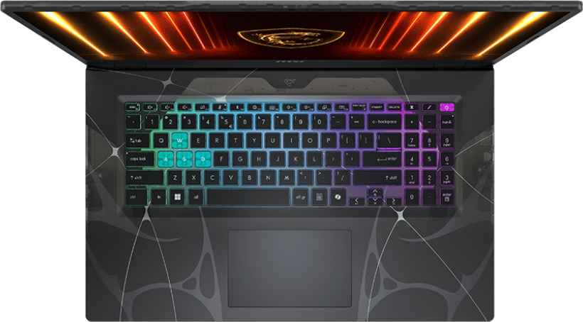 Draufsicht auf einen Laptop mit beleuchteter, mehrfarbiger Tastatur. Der Bildschirm zeigt ein Design, und der Laptop hat eine dunkle, gemusterte Oberfläche.