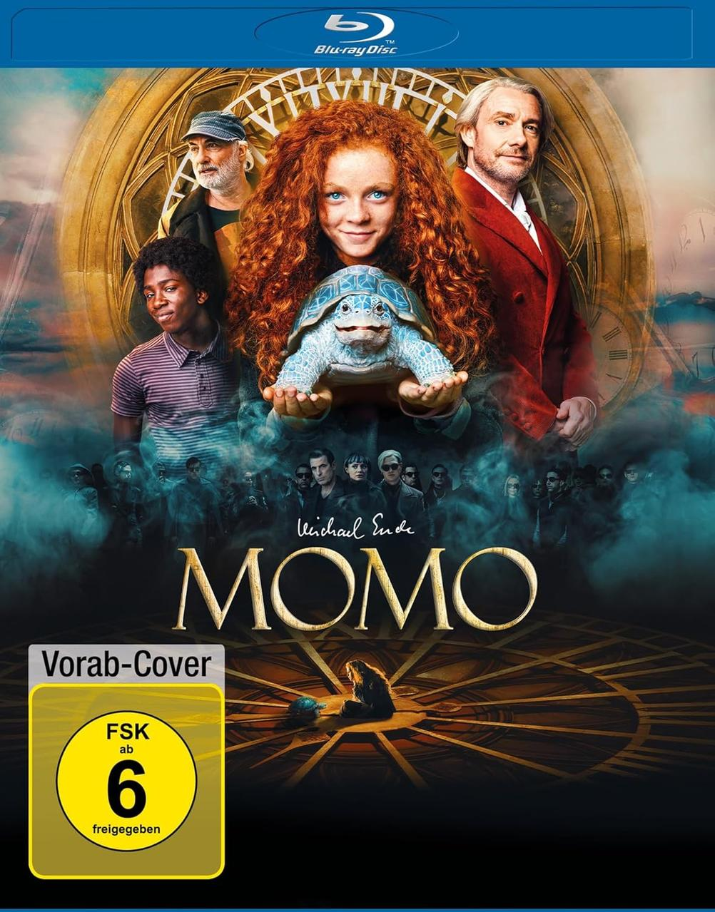 Blu-ray-Cover für Momo. Ein Mädchen hält eine Schildkröte. Andere Personen sind im Hintergrund. Der Titel lautet Momo.