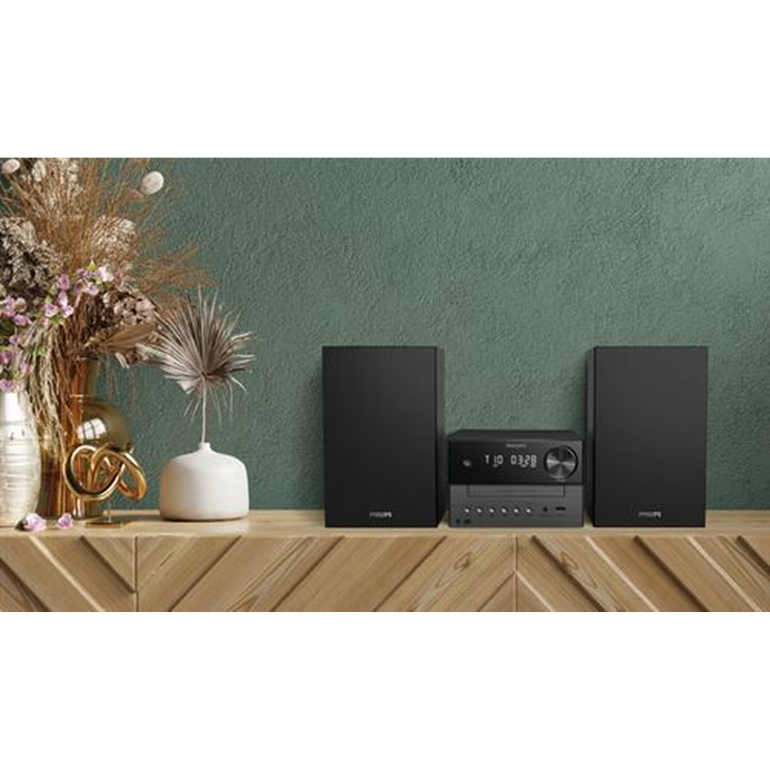 A wooden shelf with a stereo system. Two black speakers flank the stereo. A vase of flowers and a white vase are to the left.