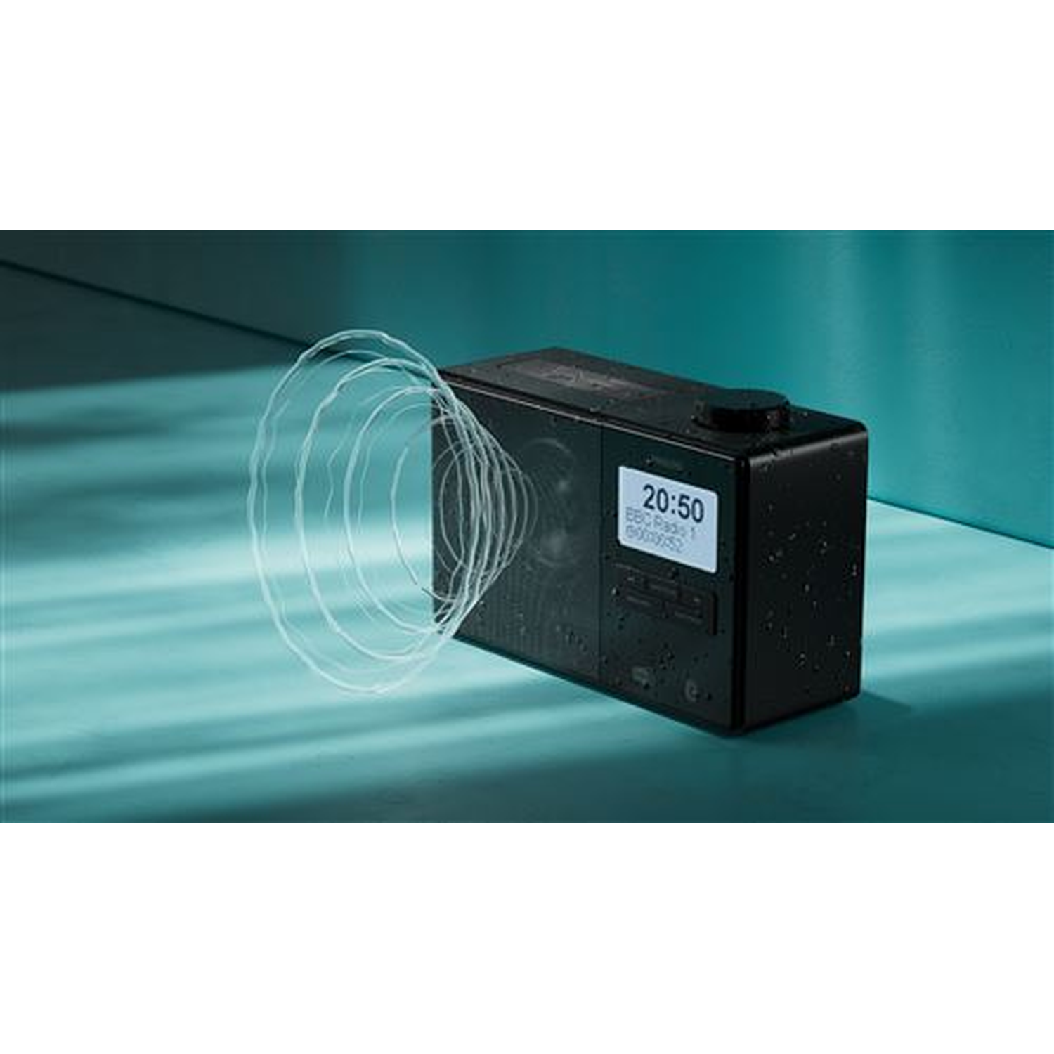 A black radio with a digital display showing time. White sound waves emanate from it. The background is teal.