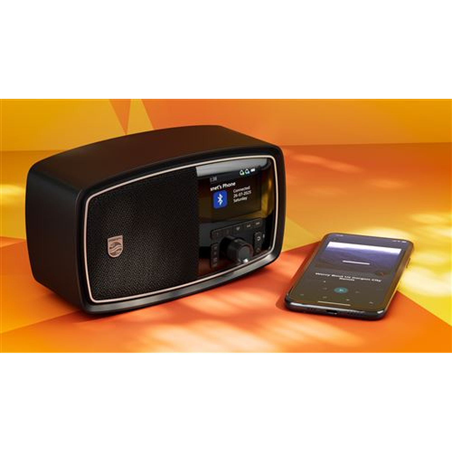 A black radio with a gold trim and a phone are on an orange background. The phone is showing music. The radio has a screen.