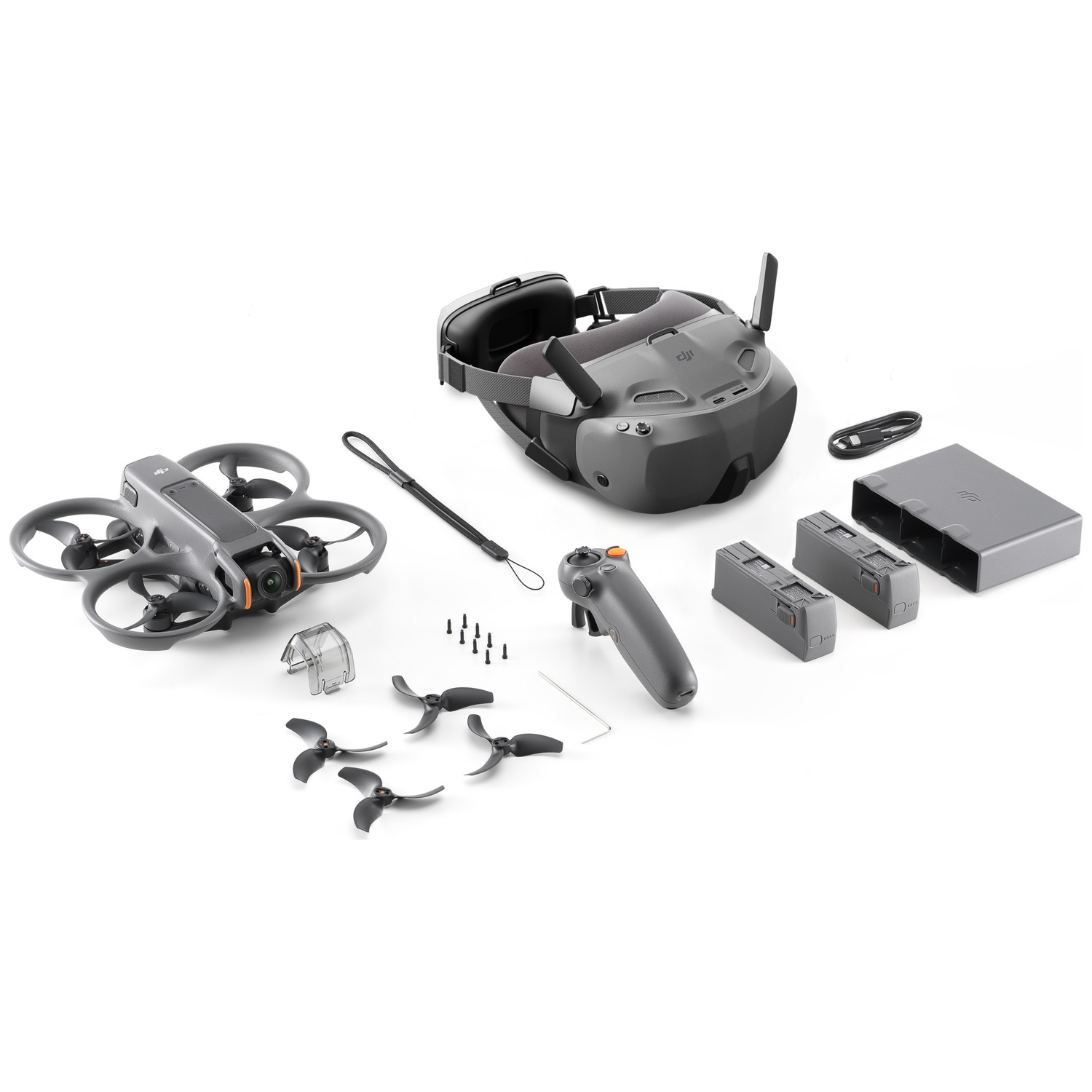 Dronekit met drone, bril, afstandsbediening, batterijen en accessoires, allemaal grijs, op witte achtergrond.