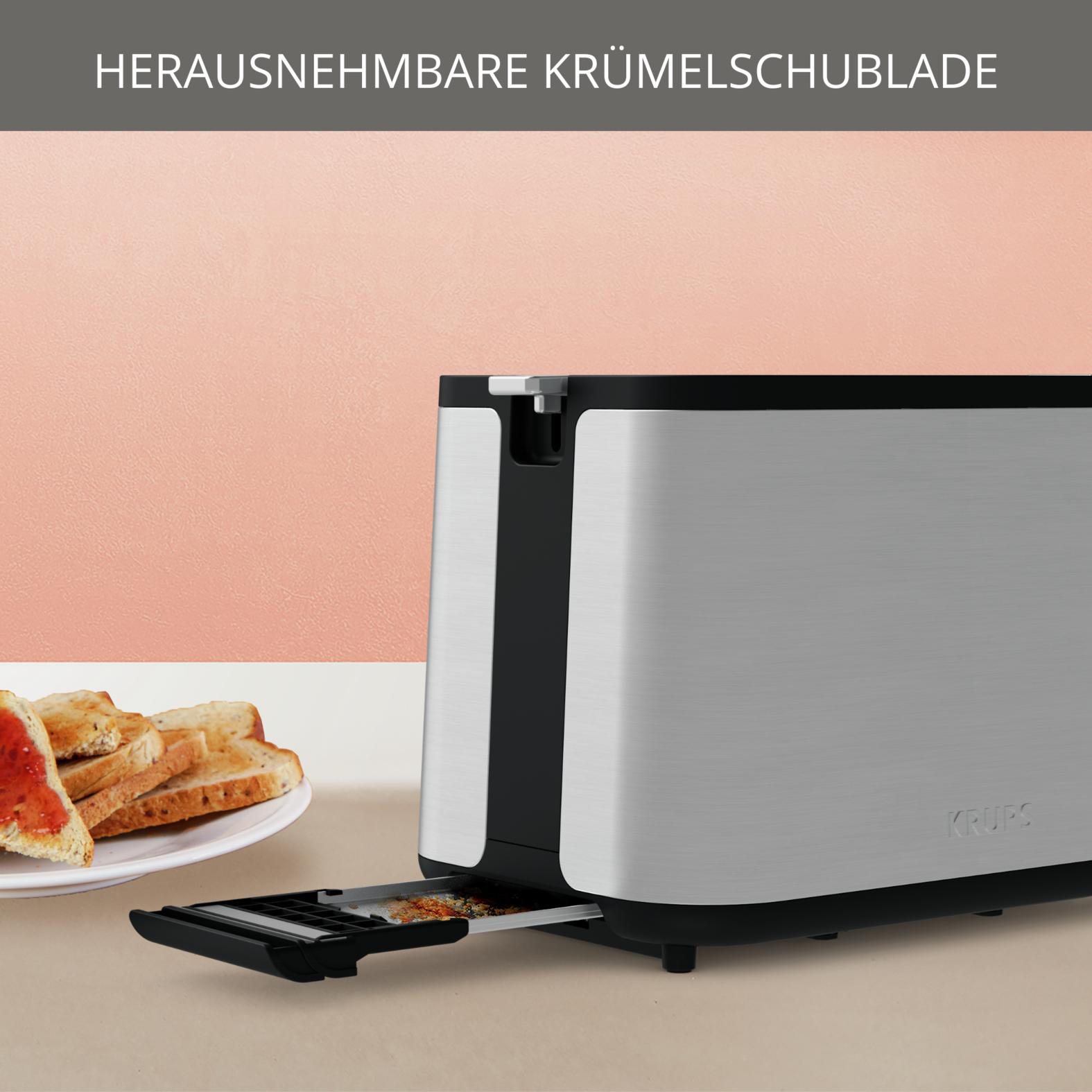 Ein silberner Toaster mit herausgezogener Krümelschublade. Toast und Marmelade liegen links auf einem Teller.