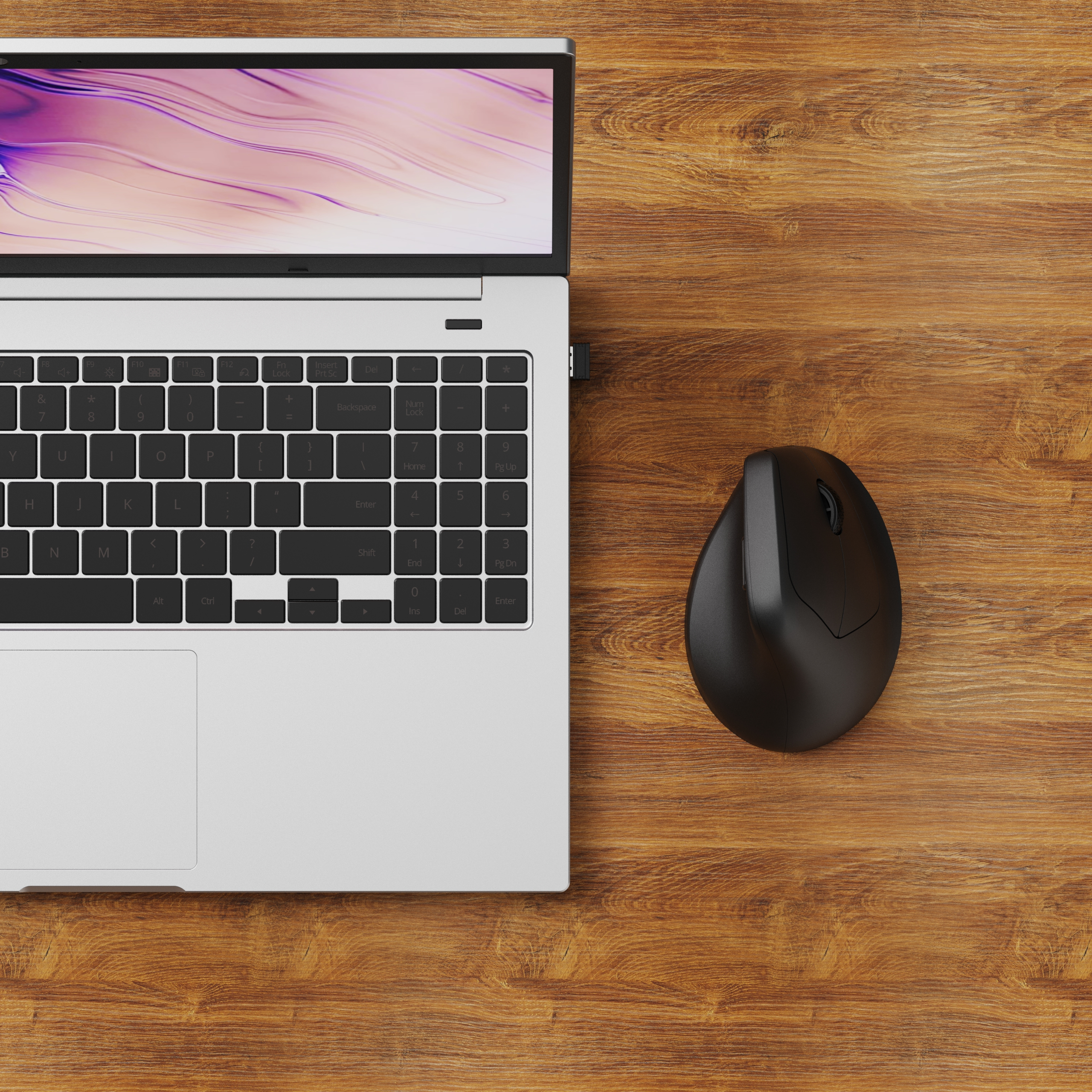 Laptop und schwarze ergonomische Maus auf Holzoberfläche. Der Laptop-Bildschirm zeigt ein rosa-weißes Design.