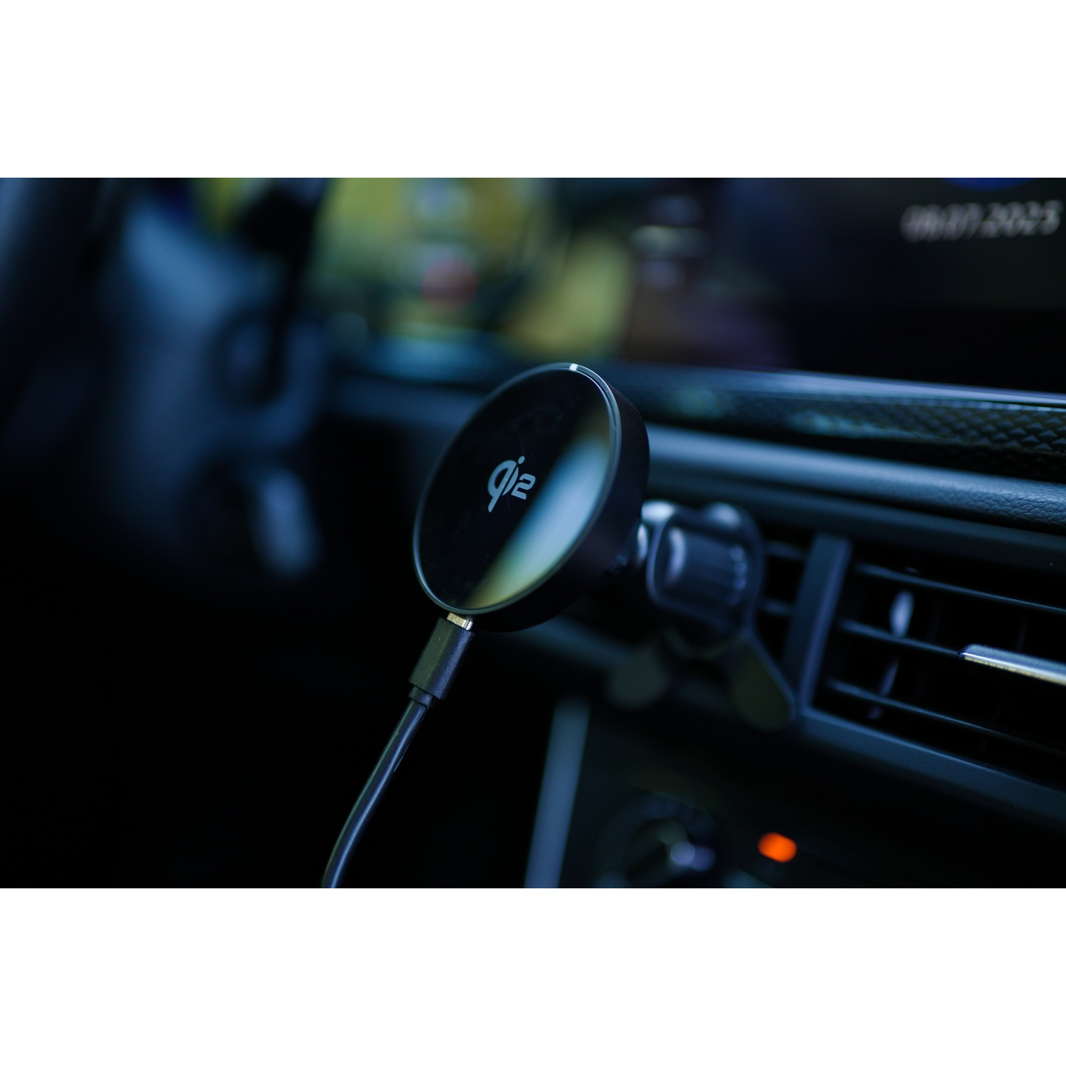 Un caricatore wireless Qi2 nero montato su una bocchetta dell'aria dell'auto. Lo sfondo mostra parte dell'interno dell'auto.