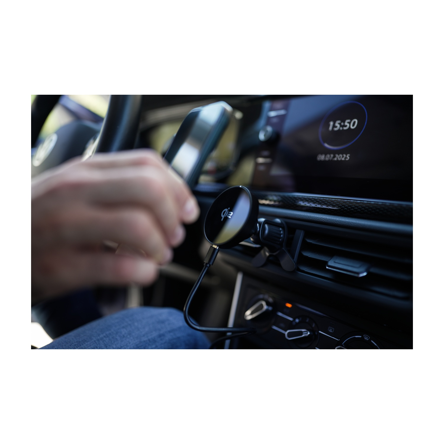 Un telefono è montato sul cruscotto di un'auto. Una mano tiene il telefono. Il display mostra l'ora e la data.