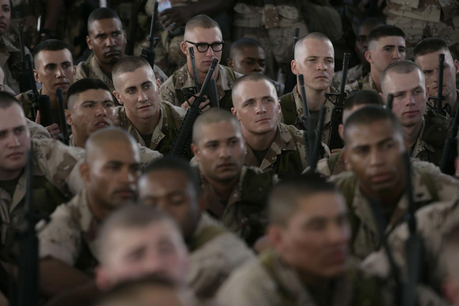 Eine Gruppe von Soldaten in Uniform, die Gewehre halten. Einige schauen in die Kamera. Die meisten haben Kurzhaarschnitte.