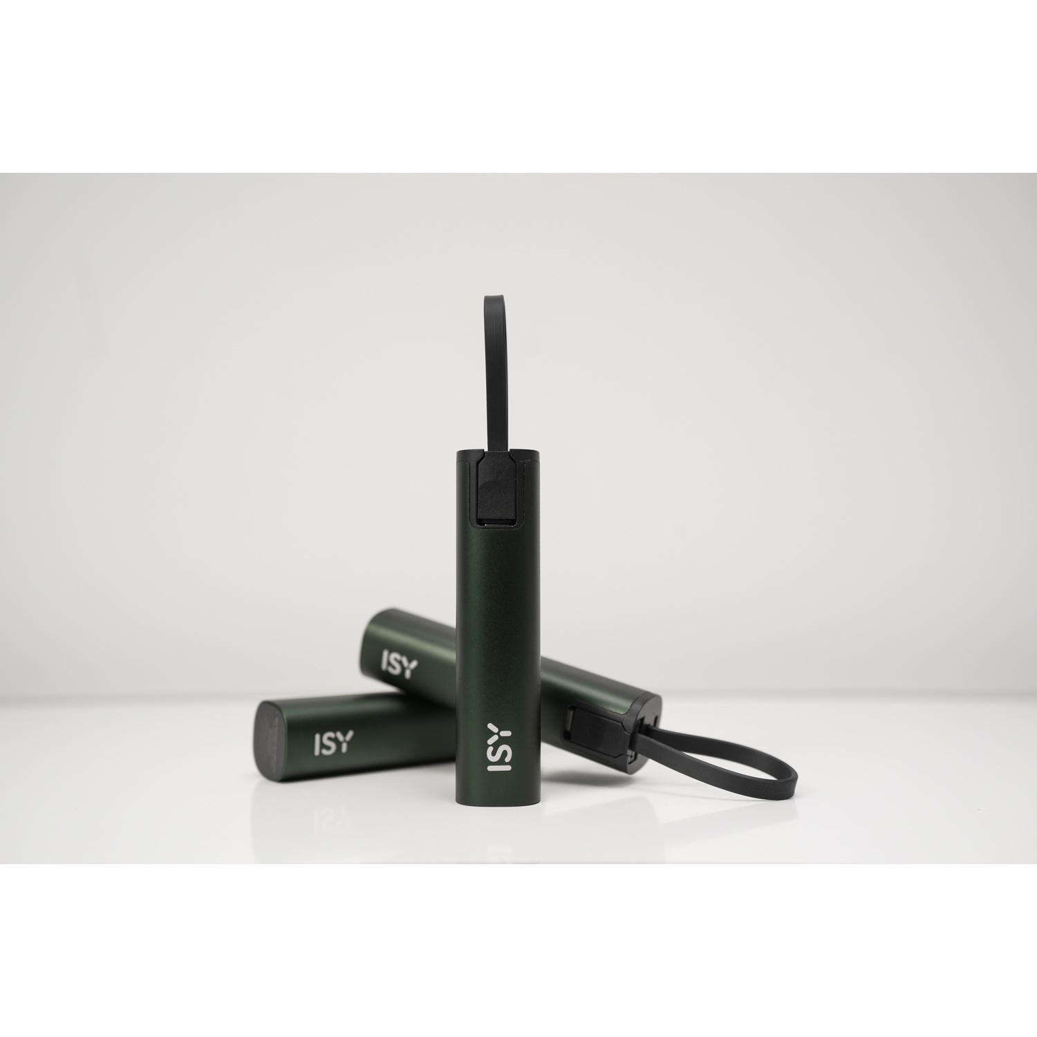 Tre power bank ISY cilindrici verde scuro su una superficie bianca. Uno in piedi, due orizzontali.