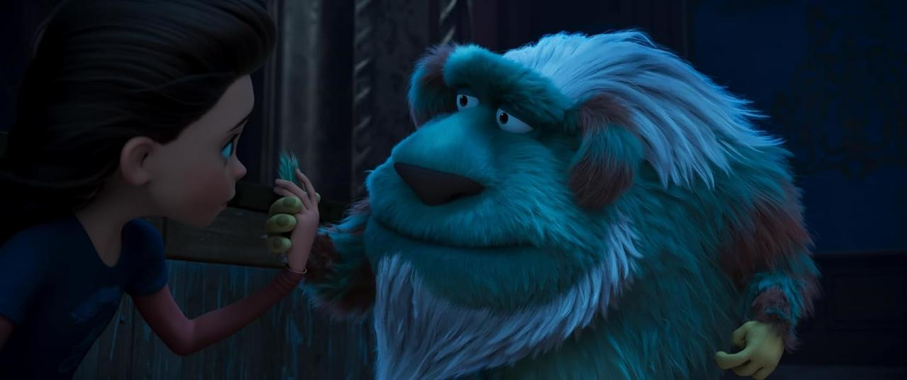 Ein Mädchen bietet einem großen, pelzigen, blauen Monster mit weißem und braunem Fell eine Feder an. Beide haben traurige Ausdrücke.