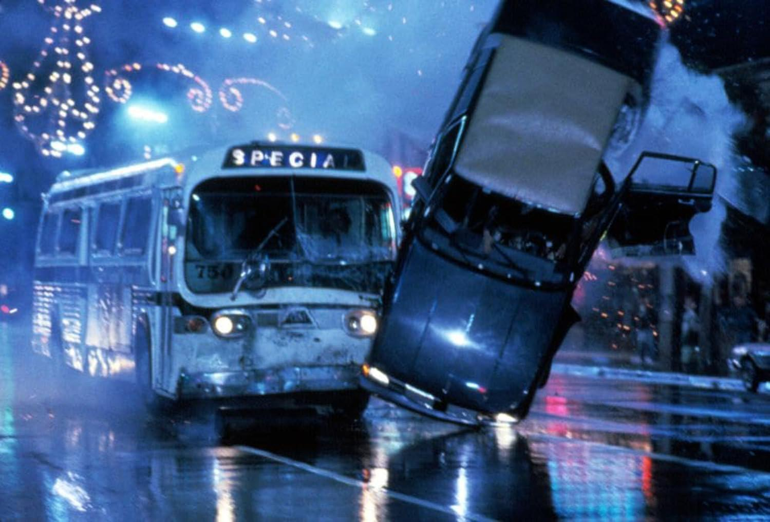 Ein Bus und ein Auto kollidieren. Der Bus trägt die Aufschrift 'SPECIAL'. Auto ist geneigt. Szene ist nass, mit Lichtern.