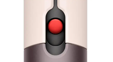 Primer plano de un ratón de ordenador con tonos beige y gris, un botón rojo en el centro.