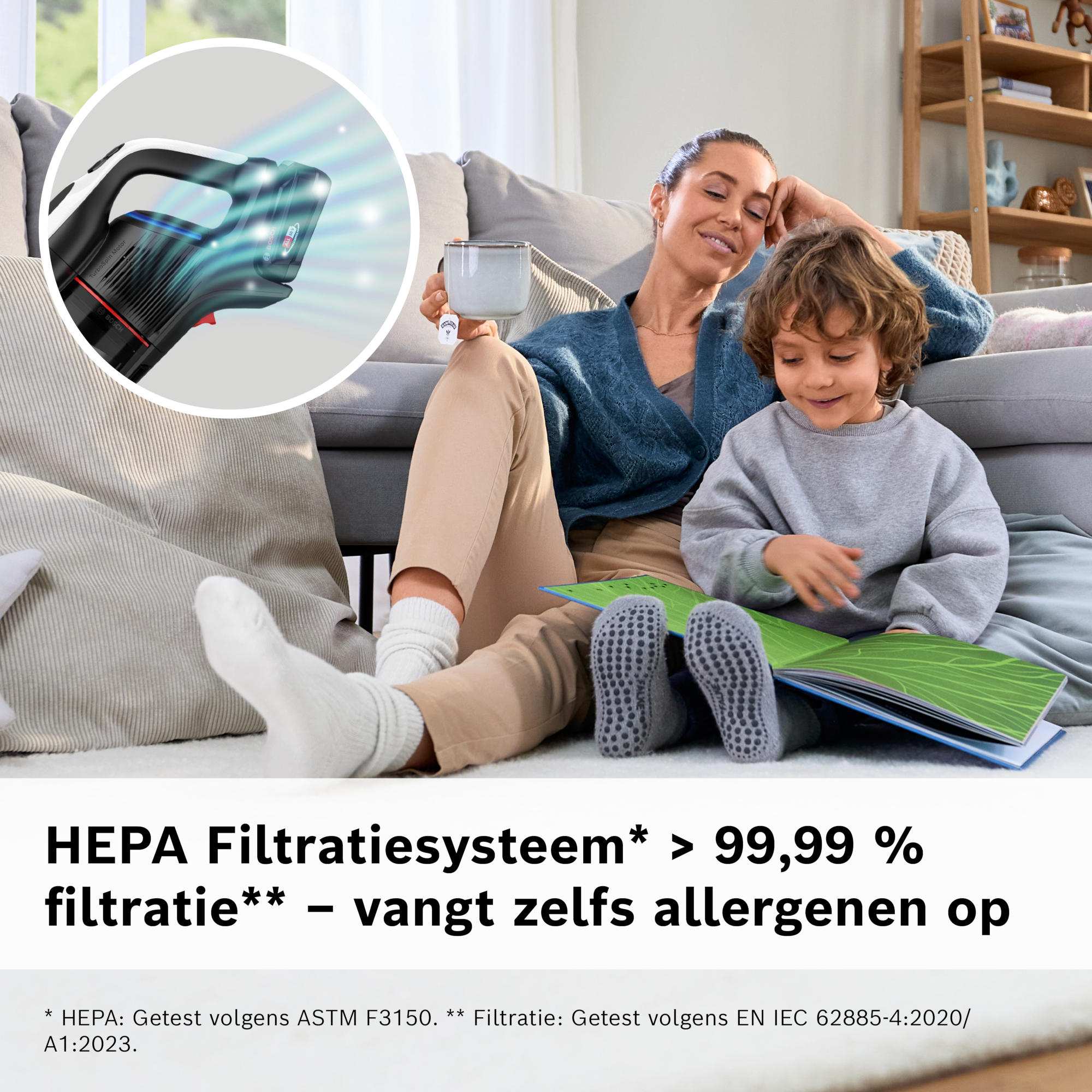 A woman and a child are reading a book. A vacuum cleaner is in the top left corner.