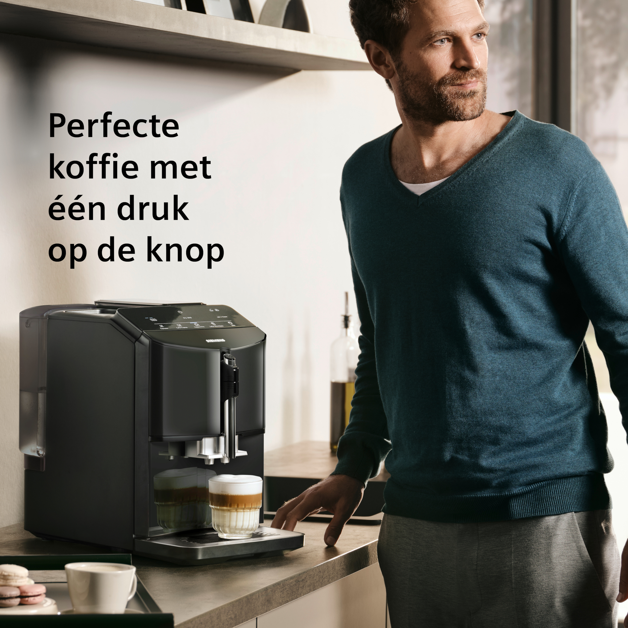 Man bij koffiemachine, maakt latte. Tekst: Perfecte koffie met één druk op de knop. Keukenomgeving.