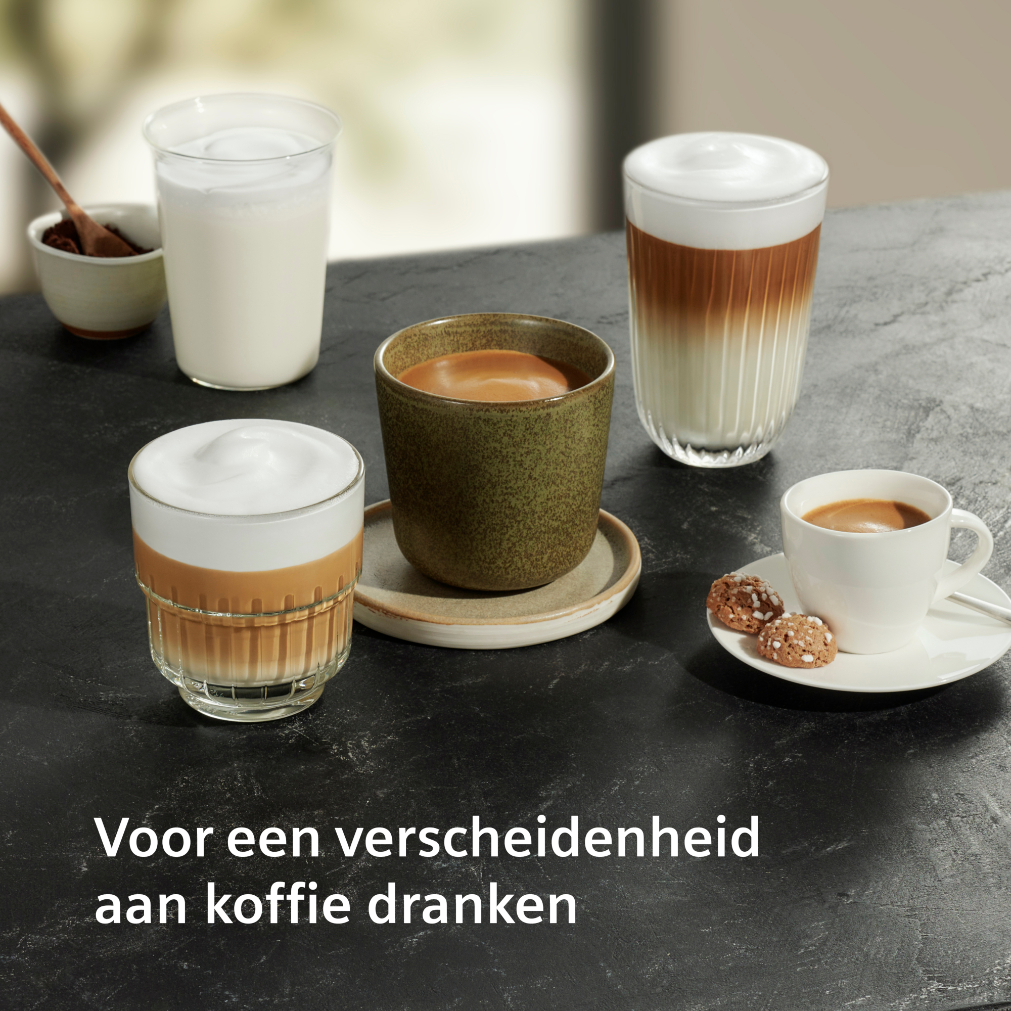 Verschillende koffiedranken op een donker oppervlak. Bevat lattes, espresso en koekjes. Tekst onderaan: 'Voor een verscheidenheid aan koffiedranken.'
