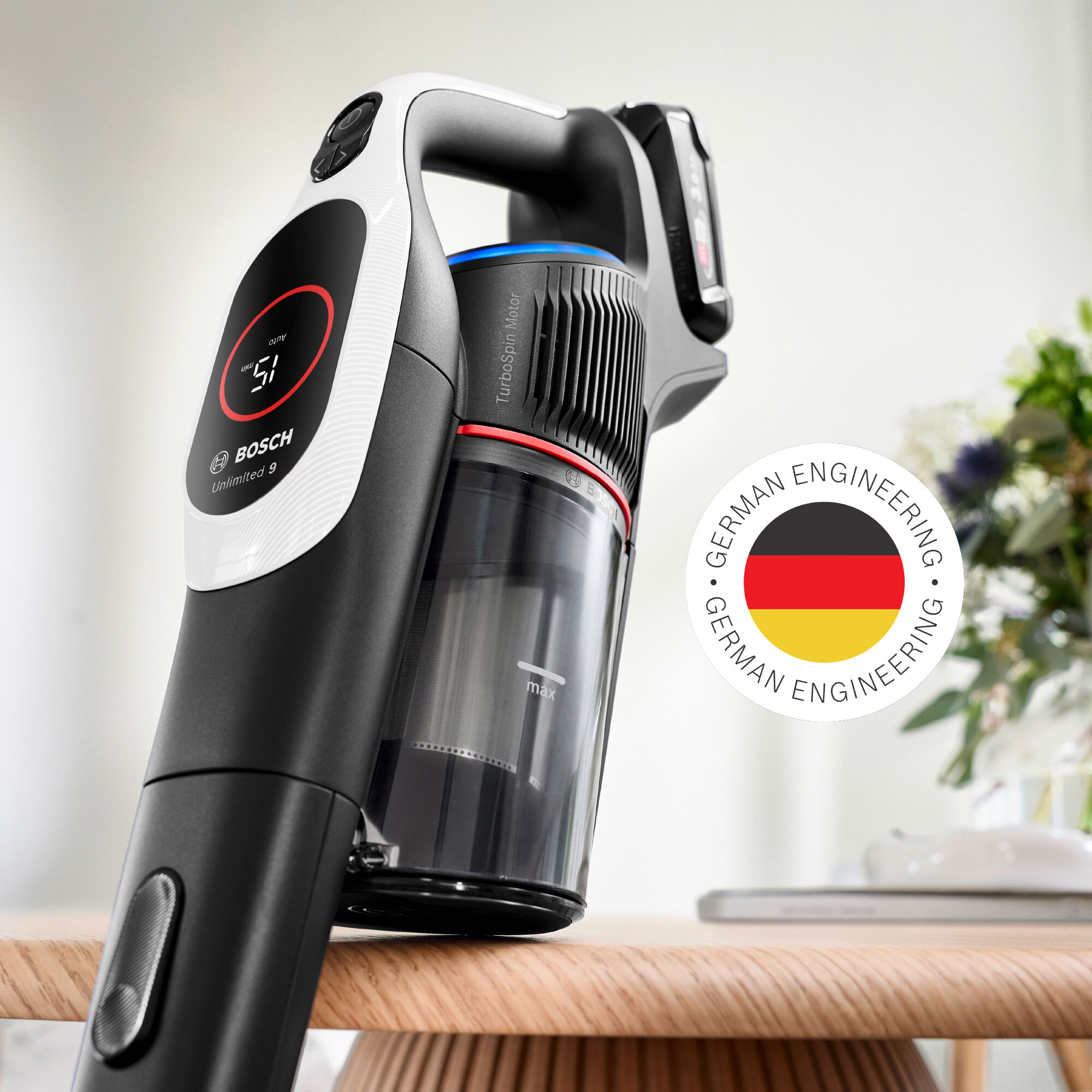 A black and white Bosch vacuum cleaner. A German engineering sticker is visible. Digital display shows '51'.