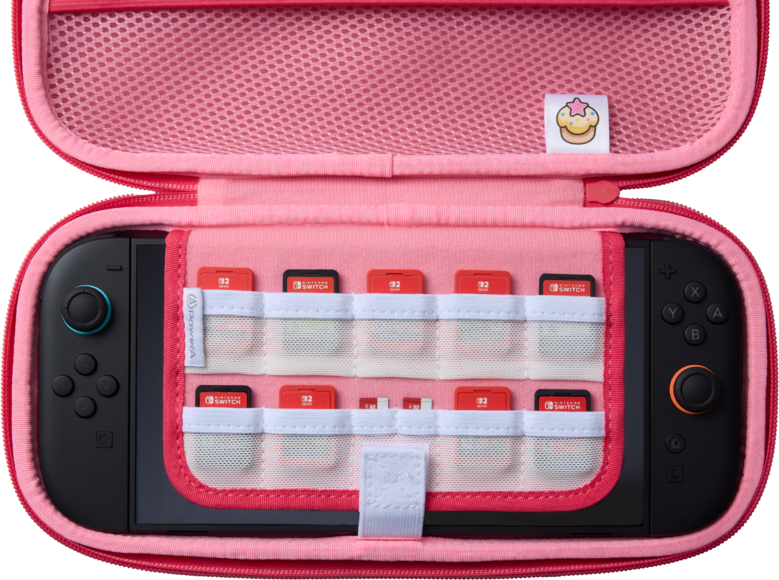Rózsaszín Nintendo Switch tok, nyitva. Switch konzol belül, játékpatronok láthatók. A tokon egy cupcake folt van.