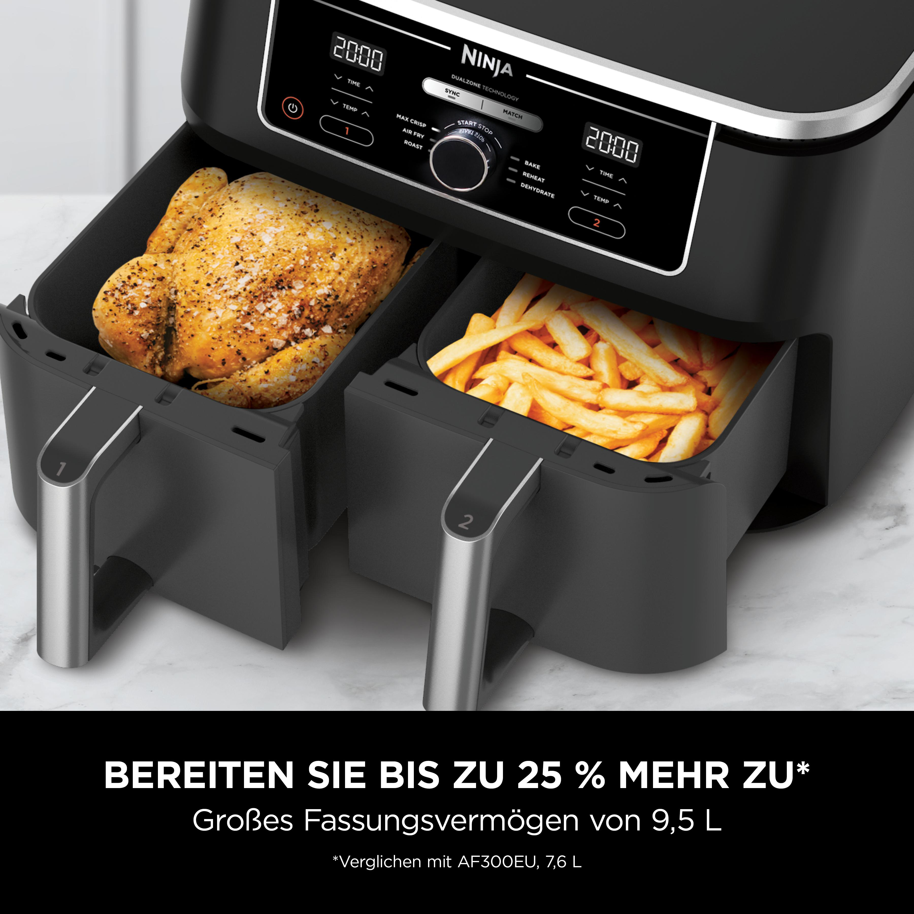 Ninja-Heißluftfritteuse mit gebratenem Huhn und Pommes. Digitalanzeige und Bedienfeld sichtbar. Schwarz und Silber.