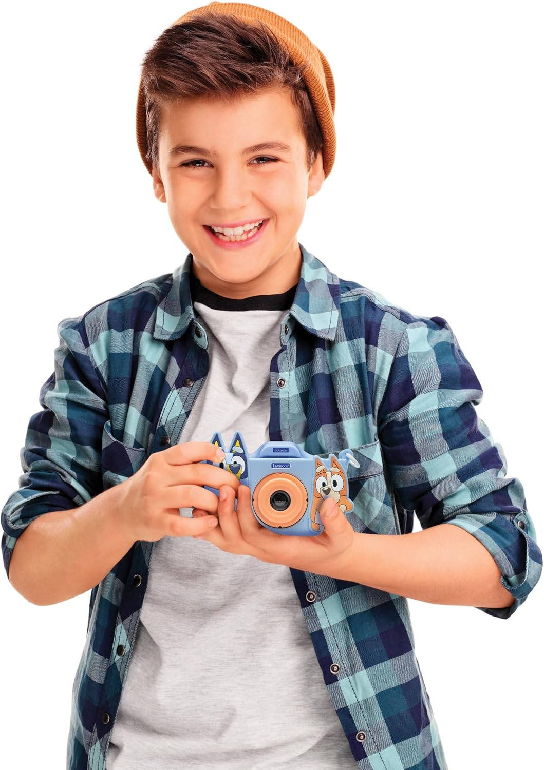 Un niño con gorro y camisa a cuadros sostiene una cámara de juguete azul con personajes de dibujos animados. Sonríe.