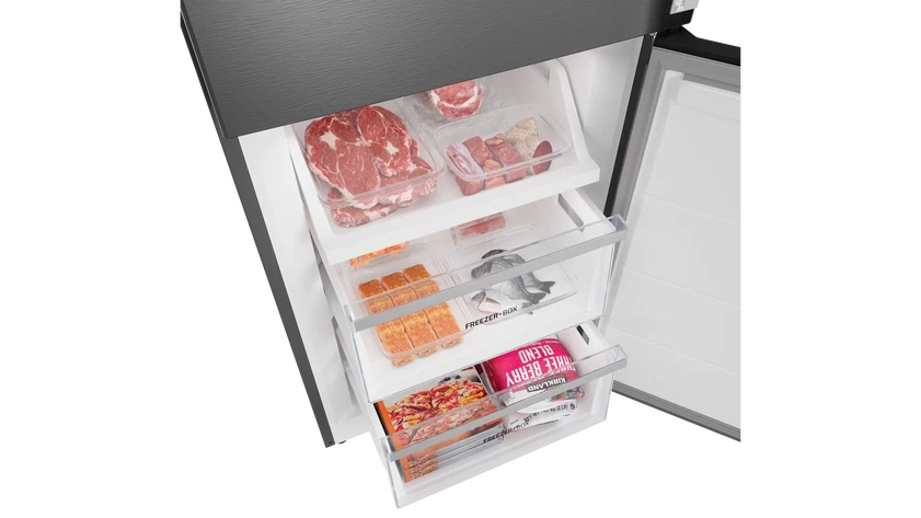 Congelador abierto con varios alimentos: carne, pescado y mezcla de bayas congeladas. Los alimentos están en recipientes transparentes.